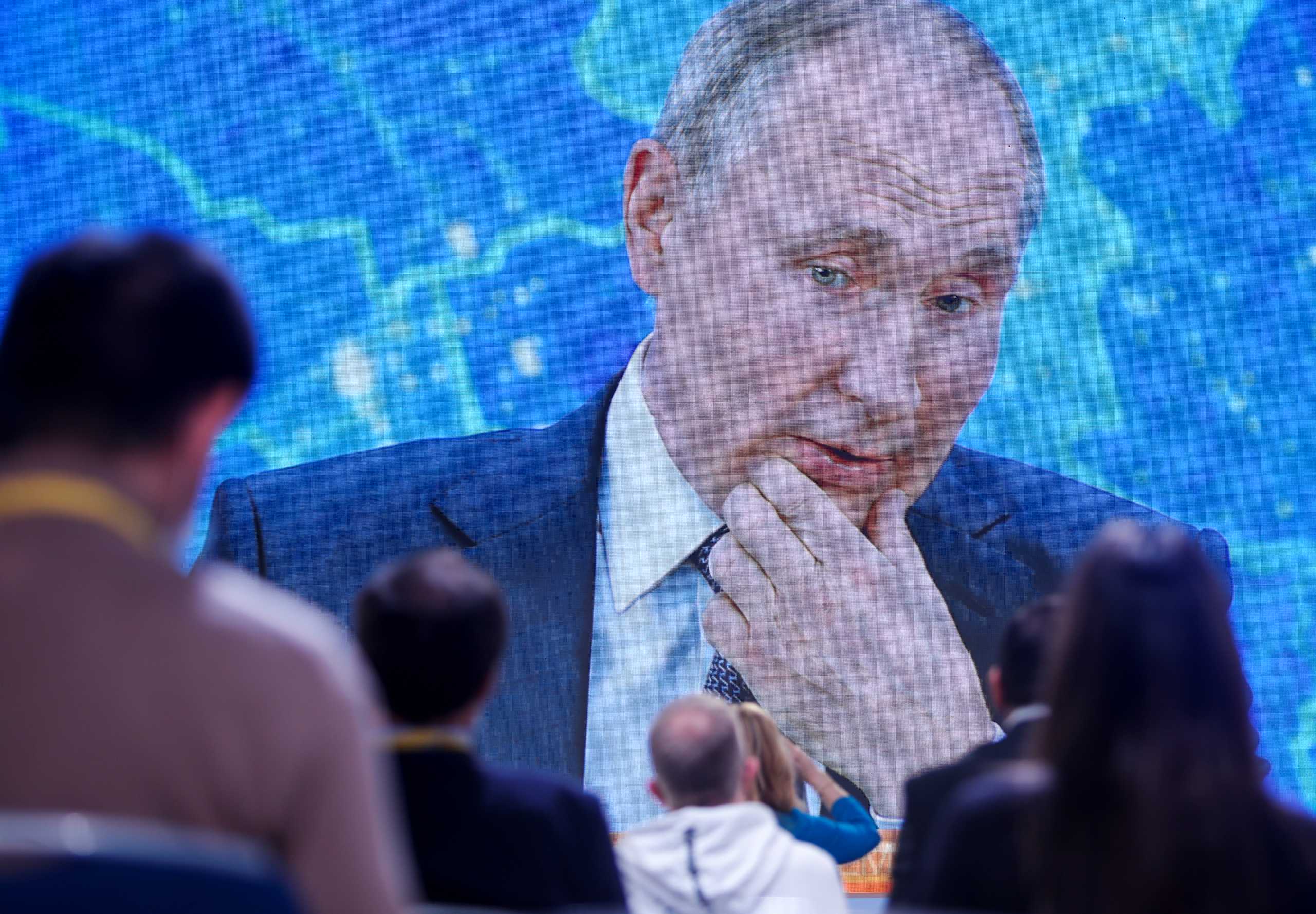 Journalists sit in front of an electronic screen during Russian President Vladimir Putin's annual end-of-year news conference, held online in a video conference mode, in Moscow, Russia December 17, 2020. REUTERS