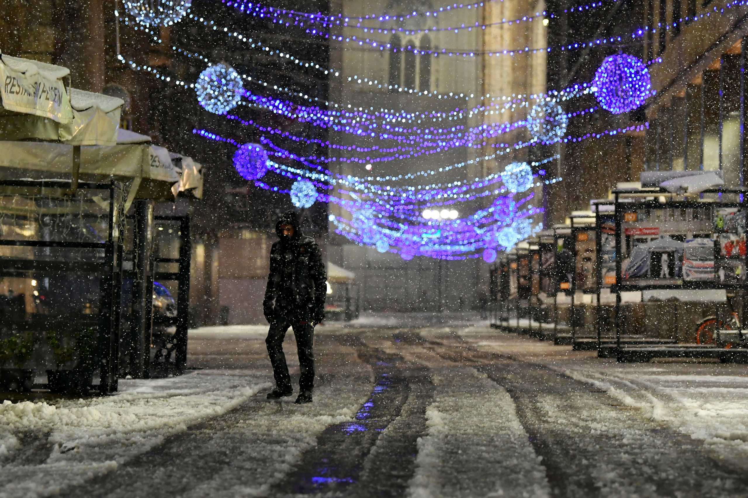 A man walks during a snowfall, in Milan, Italy December 28, 2020. REUTERS