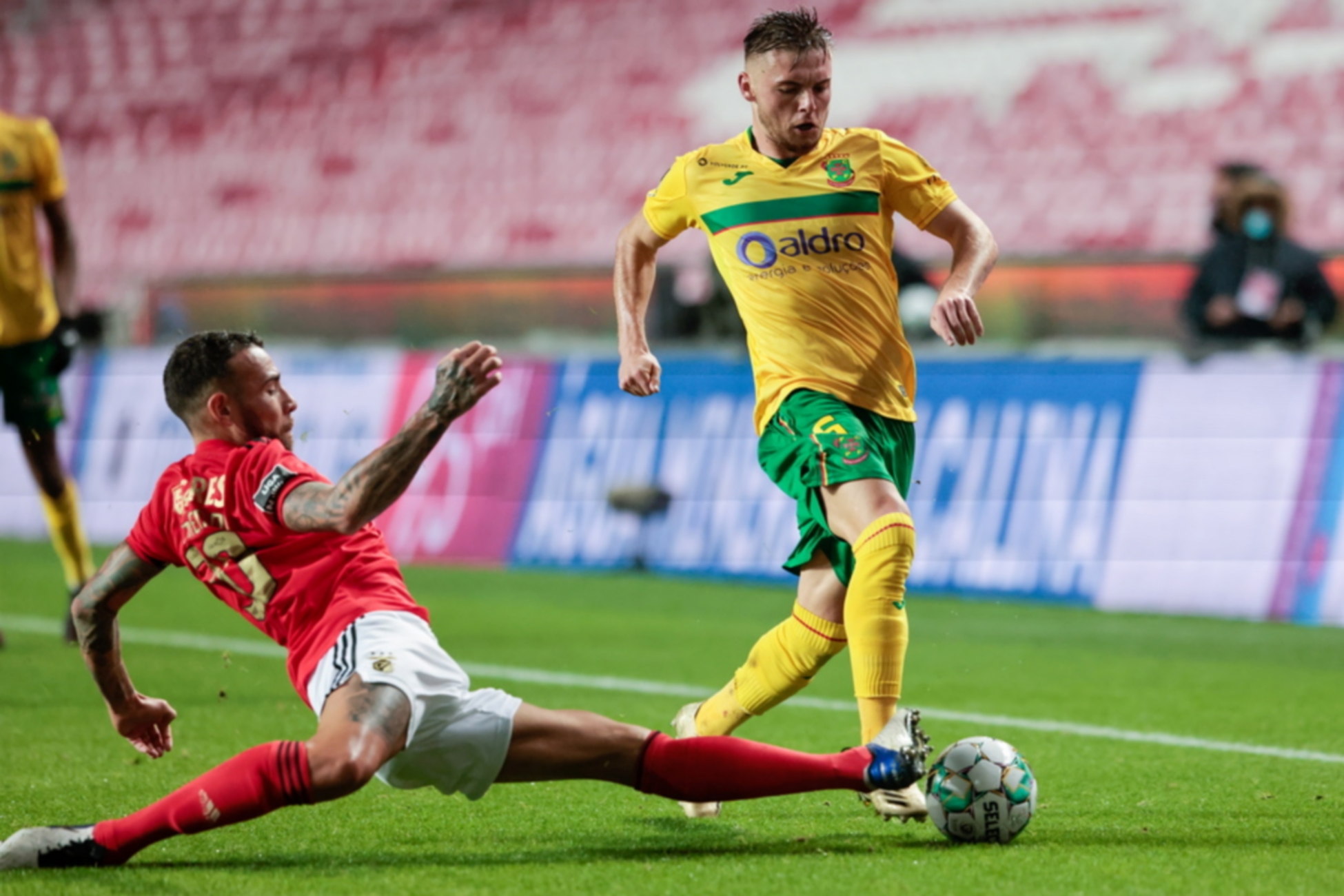 epa08867617 Benfica player Nicolas Otamendi (L) vies for the ball with Pacos de Ferreira player Oleg Reabciuk during the Portuguese First League match, held at Luz Stadium, in Lisbon, Portugal, 06 December 2020.  EPA