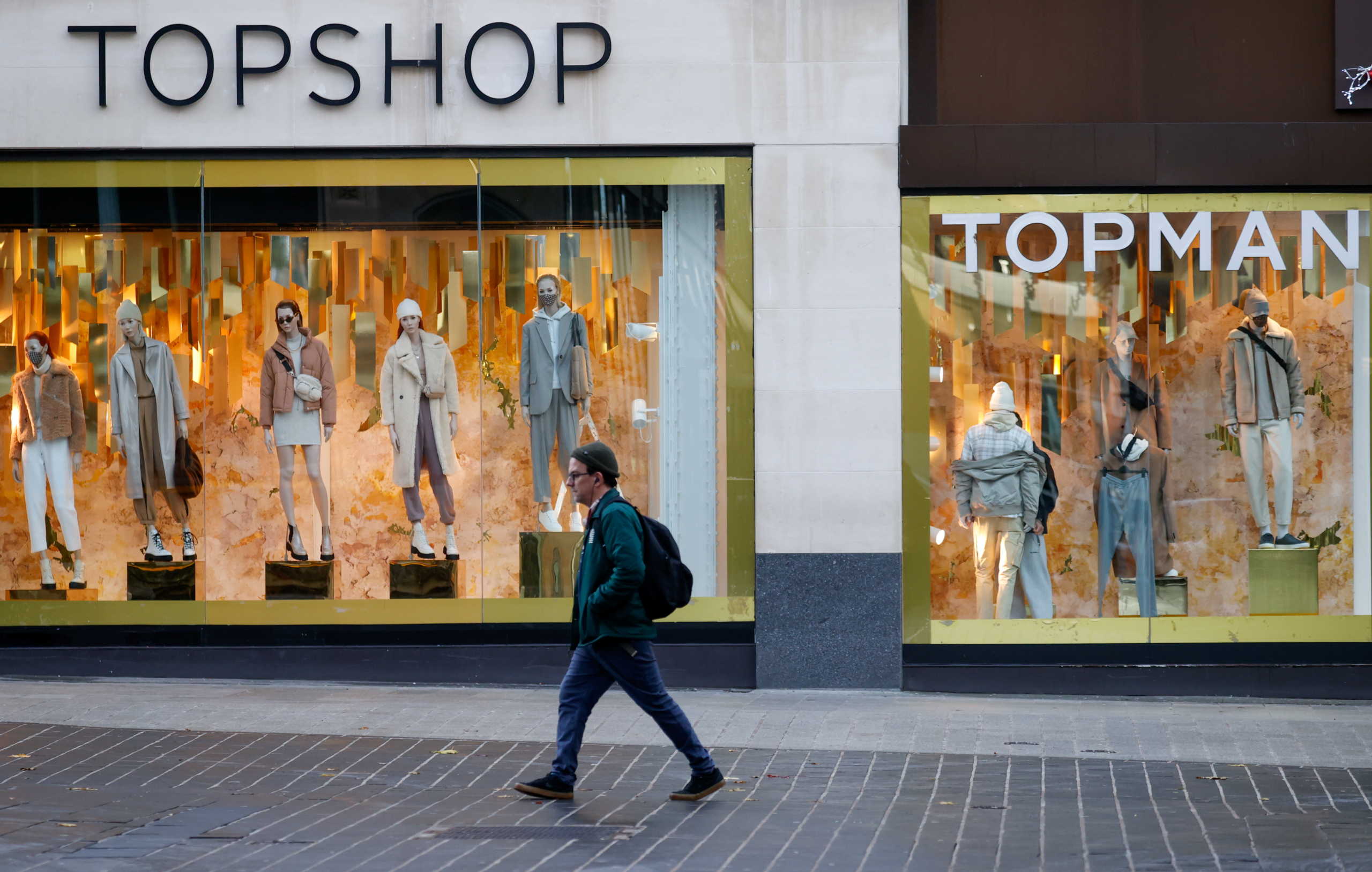 A man walks past a Topshop store, amid the outbreak of the coronavirus disease (COVID-19), in Liverpool, Britain December 1, 2020. REUTERS