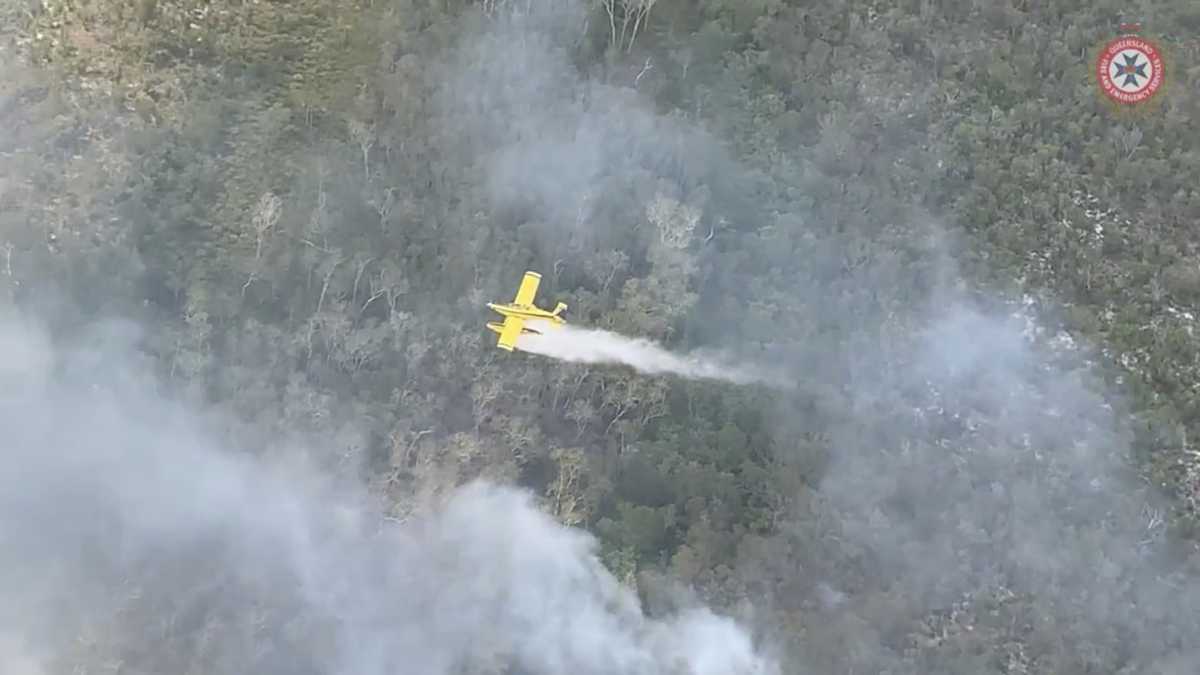 FILE PHOTO: A plane drops water over bushfires on Fraser Island, Queensland, Australia, November 27, 2020, in this still image taken from video. Queensland Fire and Emergency Services