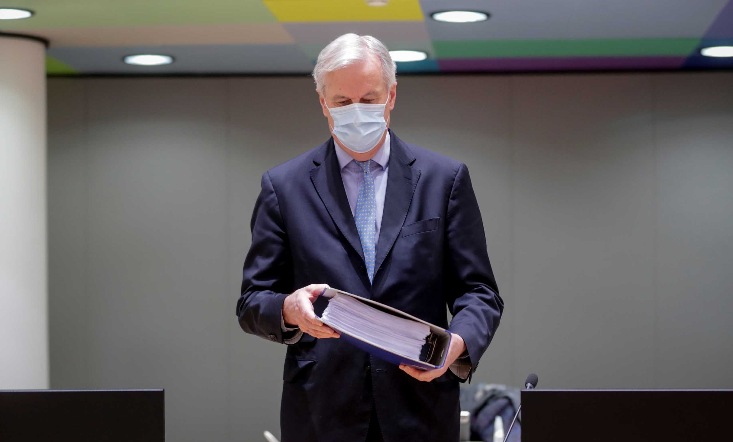 European Union's chief Brexit negotiator Michel Barnier holds the pages of Brexit trade deal as he attends a meeting of the Committee of the Permanent Representatives of the Governments of the Member States to the European Union (COREPER) in Brussels, Belgium December 25, 2020. Olivier Hoslet