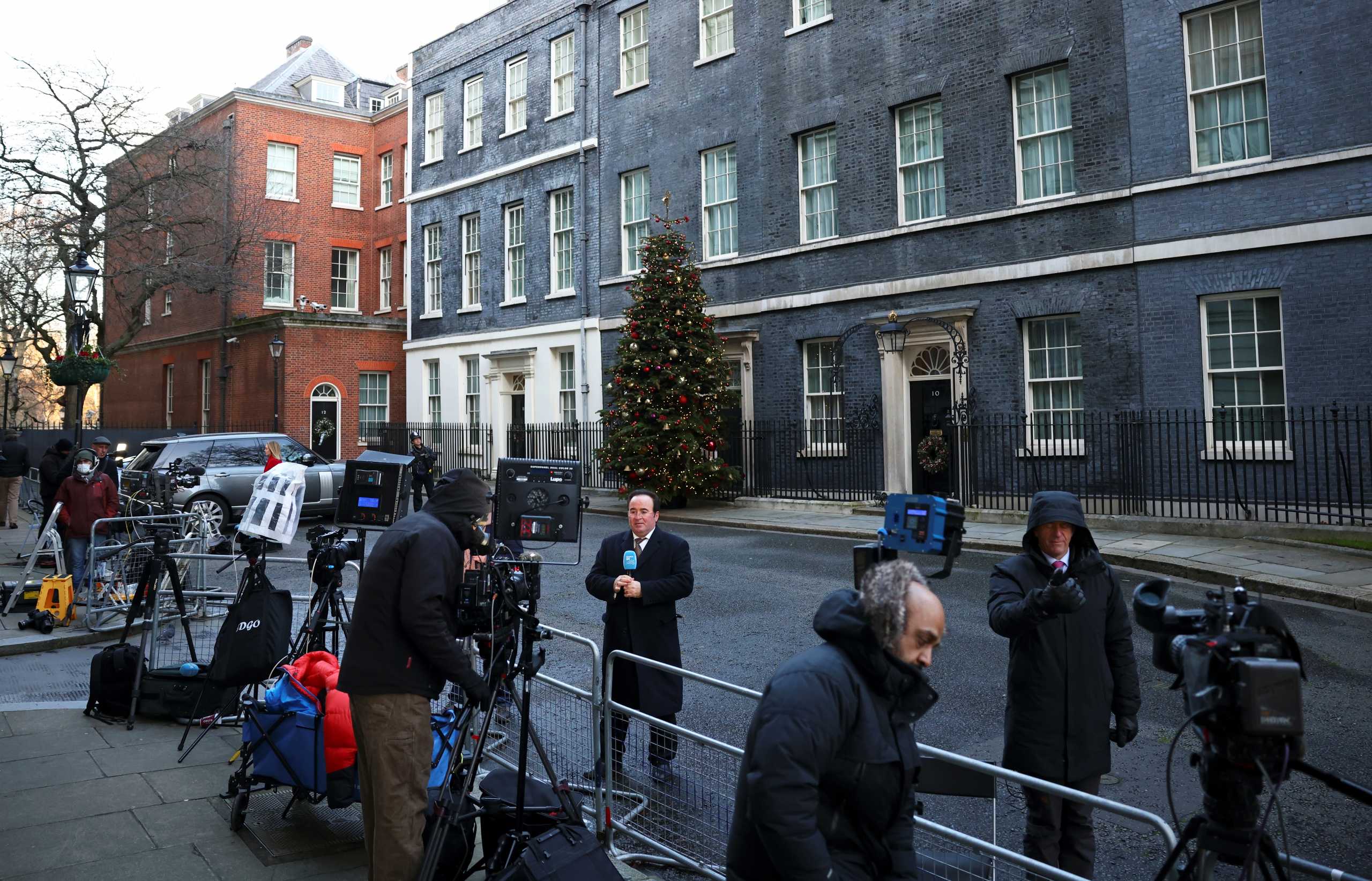 Members of the media work in front of 10 Downing Street in London, Britain, December 24, 2020. REUTERS