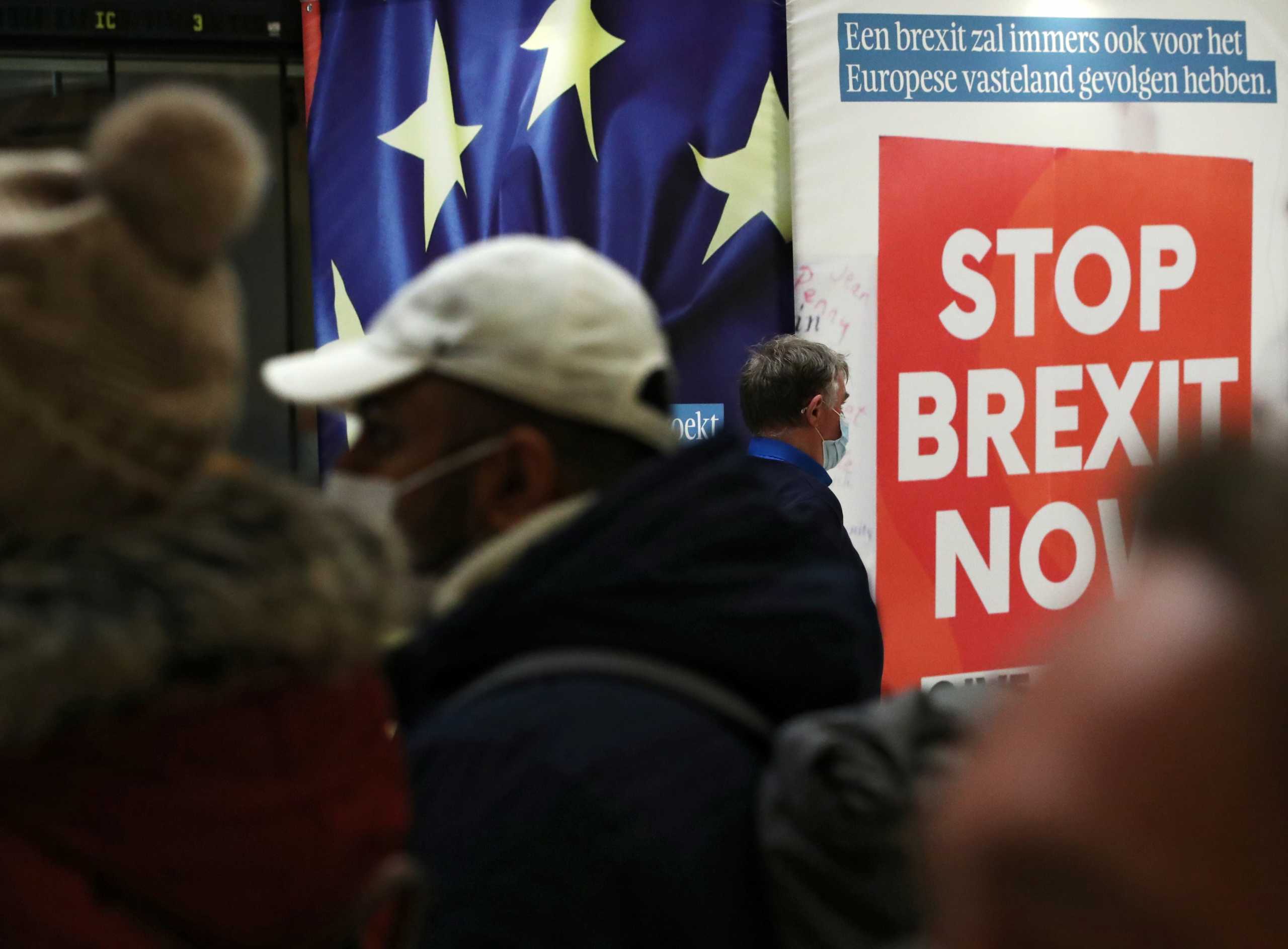 People walk past a billboard depicting a photo of a placard reading "Stop Brexit Now" at Central railway station in Brussels, Belgium December 17, 2020.  REUTERS