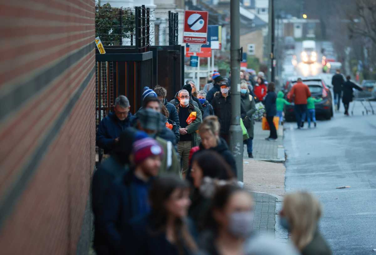 People queue outside the Waitrose and Partners supermarket, amid the coronavirus disease (COVID-19) outbreak, in London, Britain December 22, 2020. REUTERS
