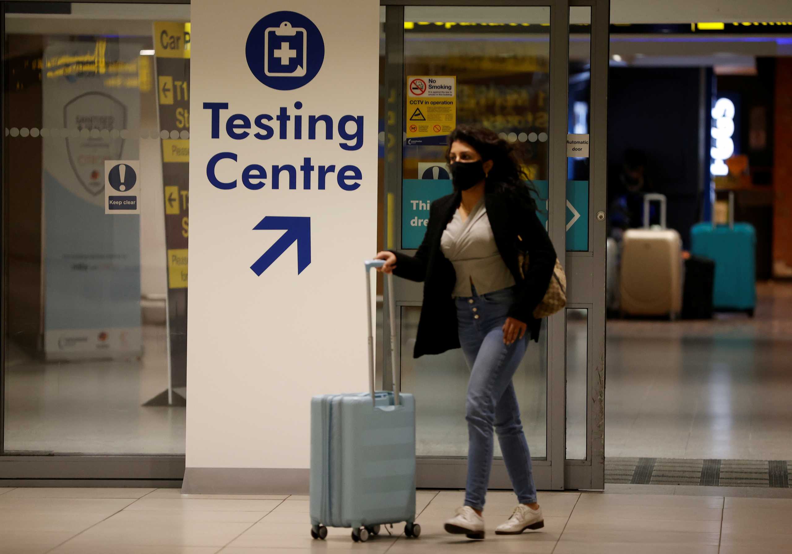A passenger walks past a testing centre sign in the terminal building of Manchester Airport amid the outbreak of the coronavirus disease (COVID-19) in Manchester, Britain, December 3, 2020. REUTERS