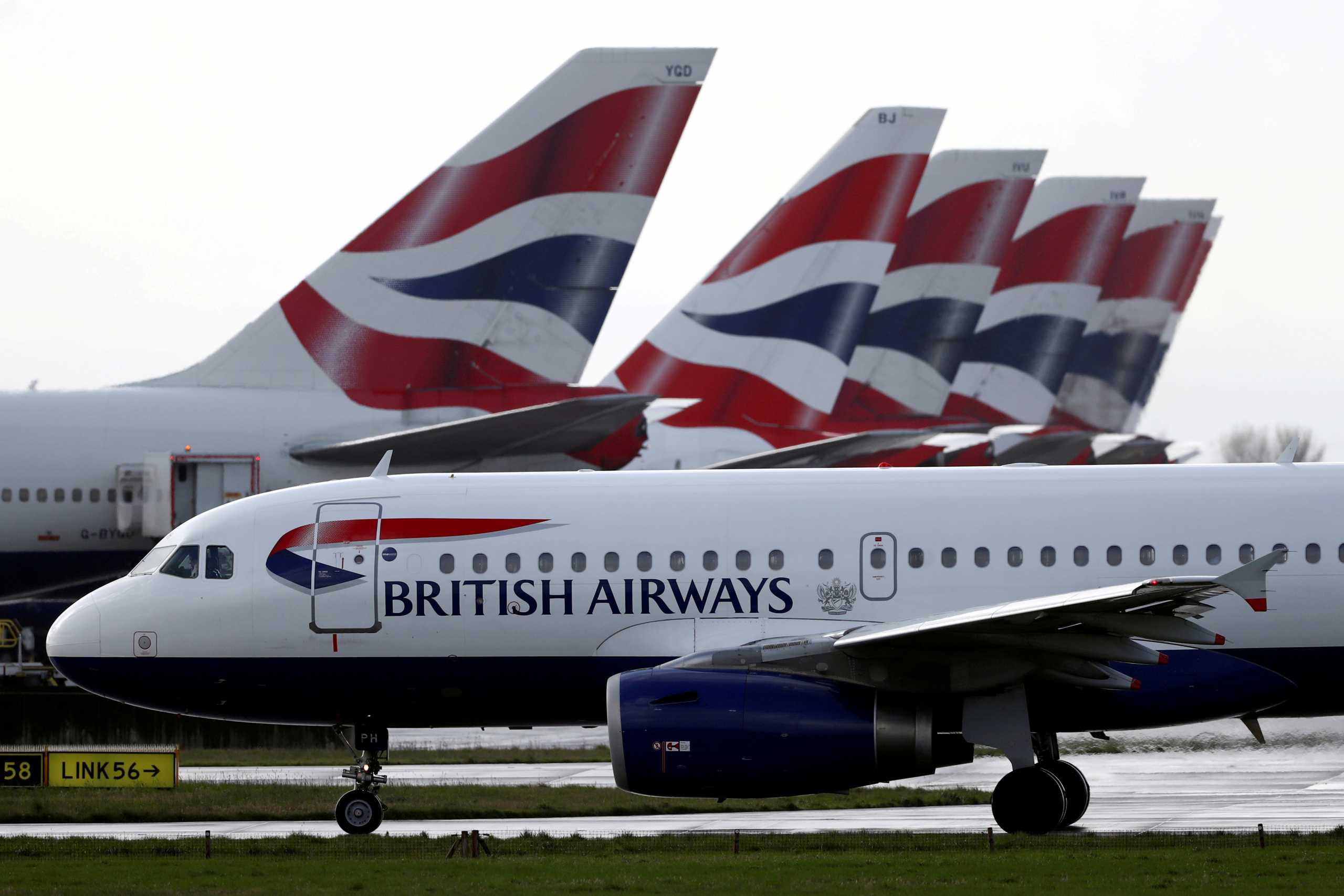 FILE PHOTO: A British Airways plane taxis past tail fins of parked aircraft near Terminal 5 at Heathrow Airport in London, Britain, March 14, 2020. REUTERS