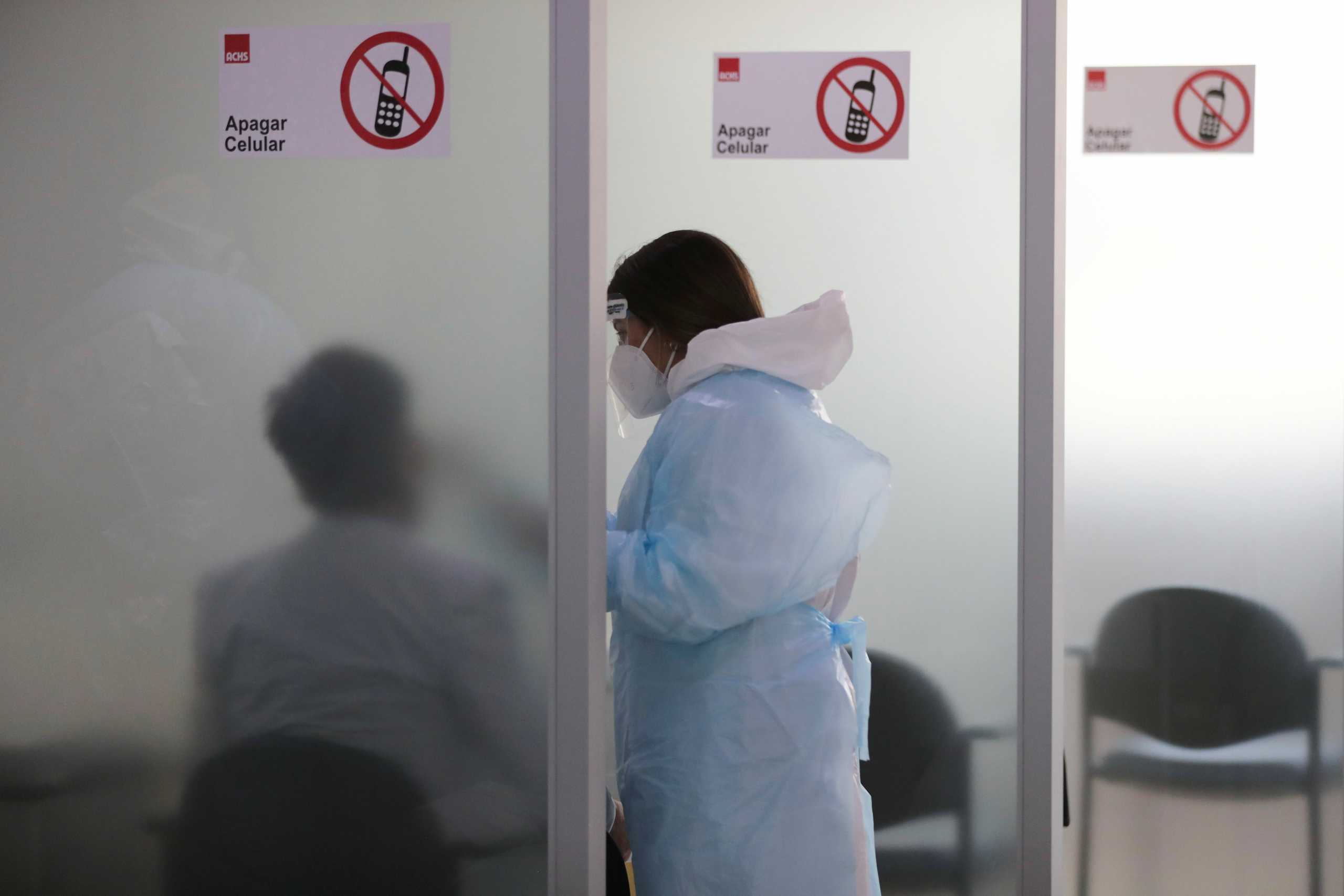 A health worker takes a nasal sample from a passenger arriving from an international flight at the International Airport of Santiago, amid the spread of the coronavirus disease (COVID-19) in Chile, December 21, 2020. REUTERS