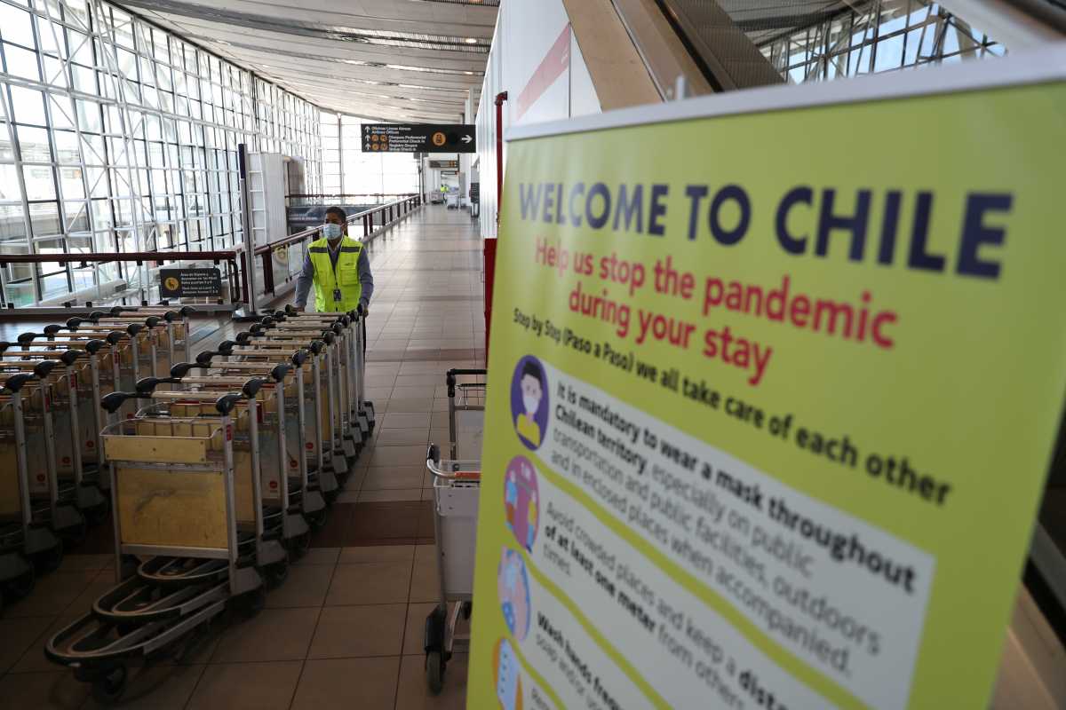A man pushes trolleys as the country opens its air border amid the spread of the coronavirus disease (COVID-19), at the  International Airport of Santiago, Chile November 23, 2020. REUTERS