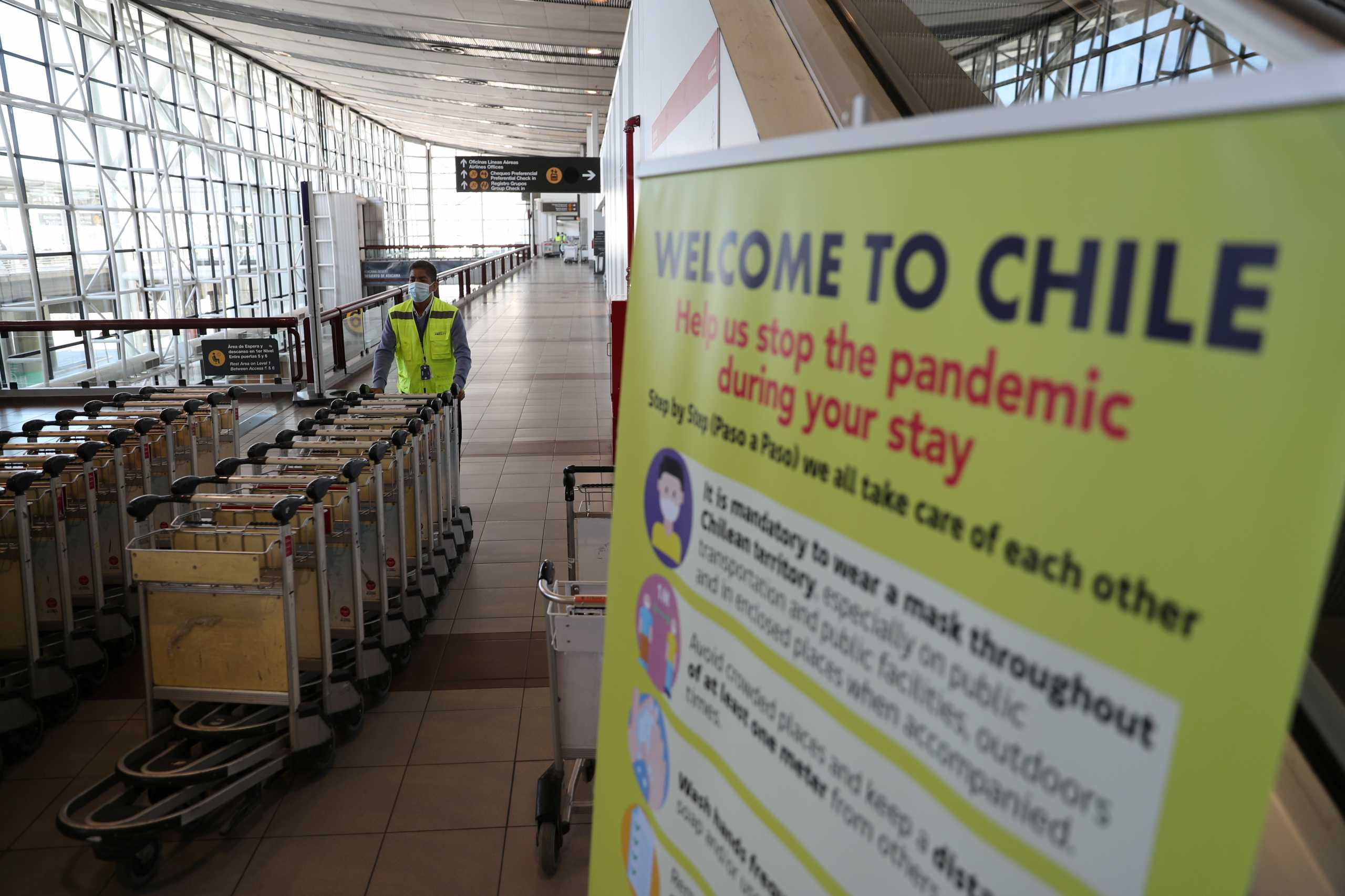 A man pushes trolleys as the country opens its air border amid the spread of the coronavirus disease (COVID-19), at the  International Airport of Santiago, Chile November 23, 2020. REUTERS