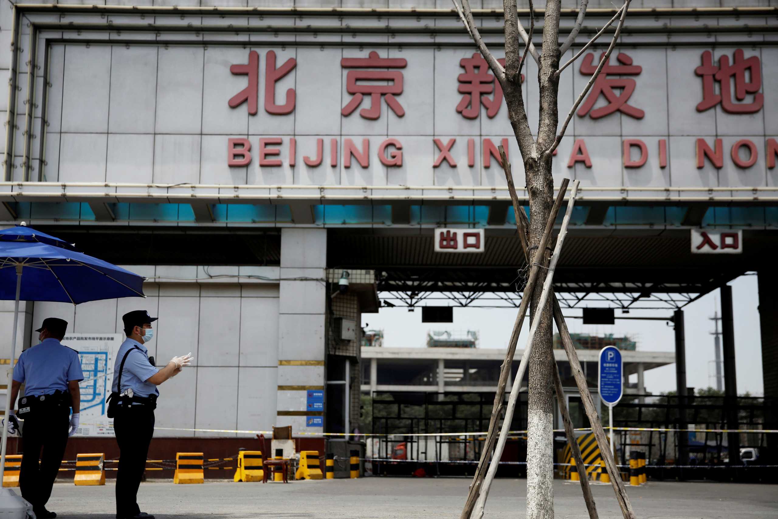 FILE PHOTO: Police officers wearing face masks and gloves stand guard outside an entrance to the Xinfadi wholesale market, which has been closed following cases of coronavirus disease (COVID-19) infections, in Beijing, China June 16, 2020.  REUTERS