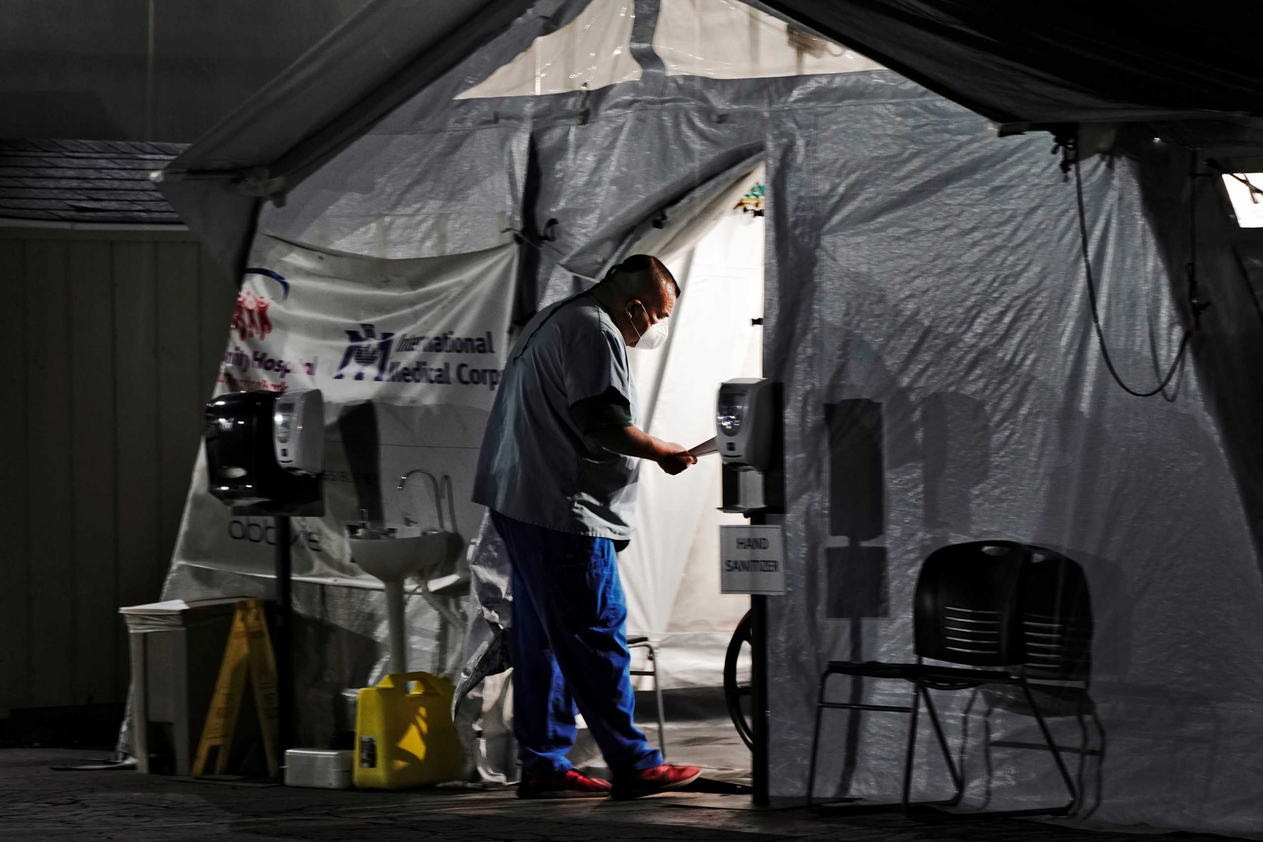 A healthcare worker checks on patients inside an oxygen tent outside the emergency room at the Community Hospital of Huntington Park during a surge in positive coronavirus (COVID-19) cases in Huntington Park, California, U.S. December 29, 2020.  REUTERS