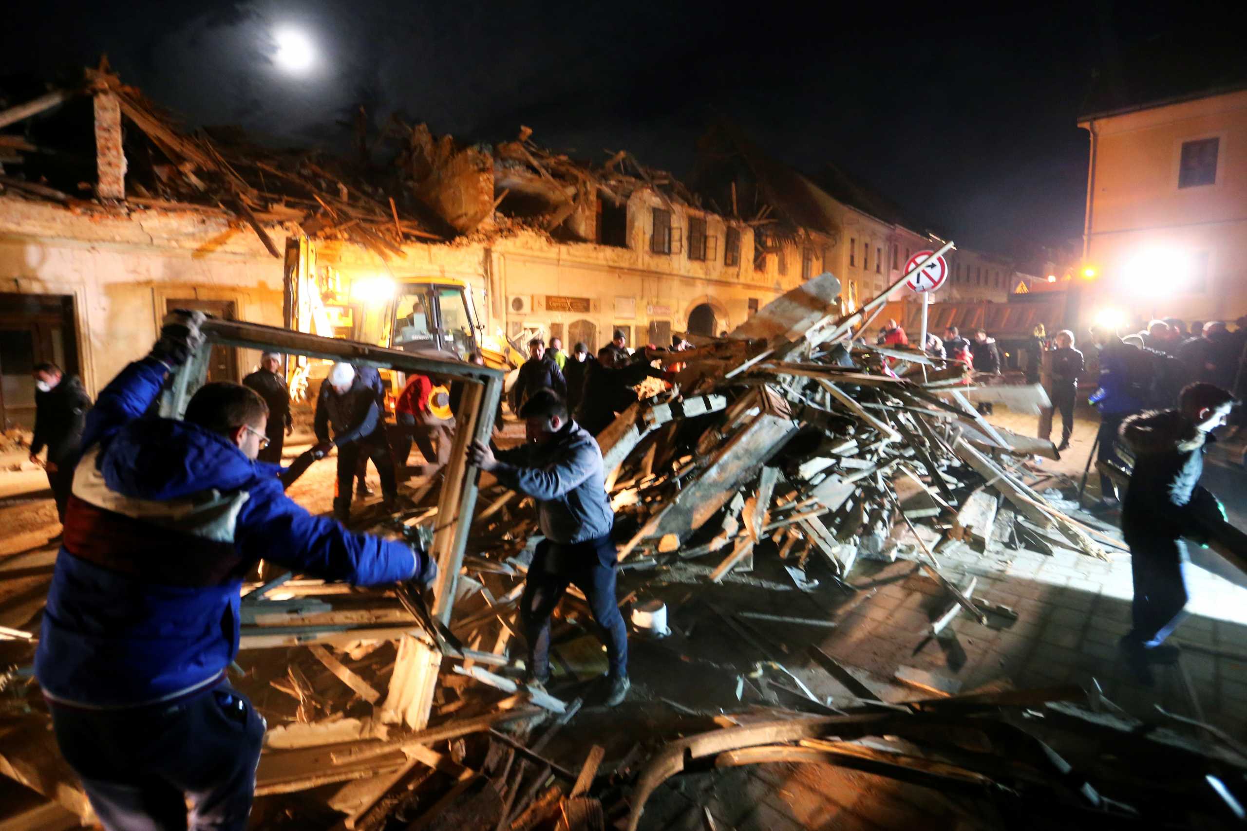 People clean debris from a street after an earthquake, in Petrinja, Croatia December 29, 2020. REUTERS