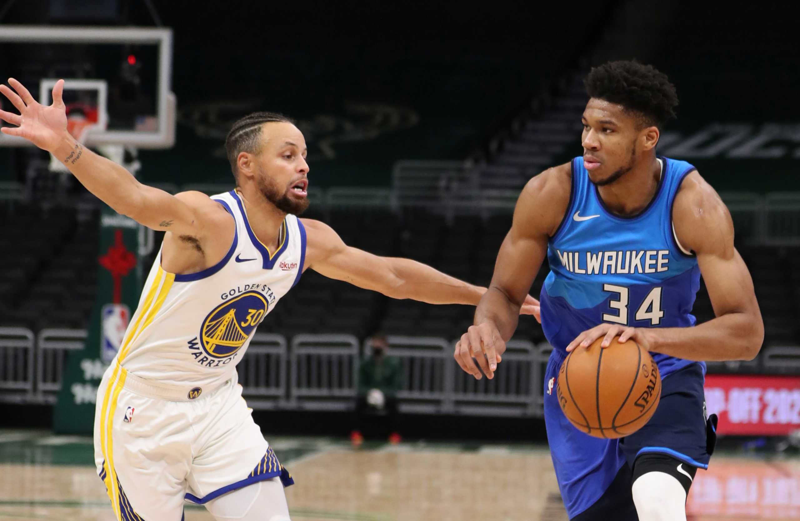 Dec 25, 2020; Milwaukee, WI, USA; Milwaukee Bucks forward Giannis Antetokounmpo (34) dribbles the ball against Golden State Warriors guard Stephen Curry (30) during a NBA game at the Bradley Center. Mandatory Credit: Nick Monroe