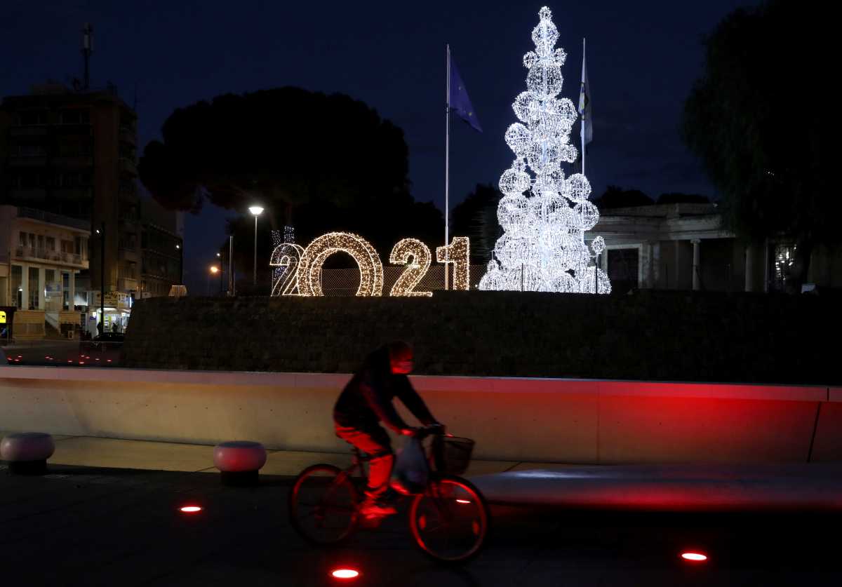 A man wearing a face mask rides a bicycle by Christmas decorations as the spread of the coronavirus disease (COVID-19) continues in Nicosia, Cyprus December, 8 2020. REUTERS