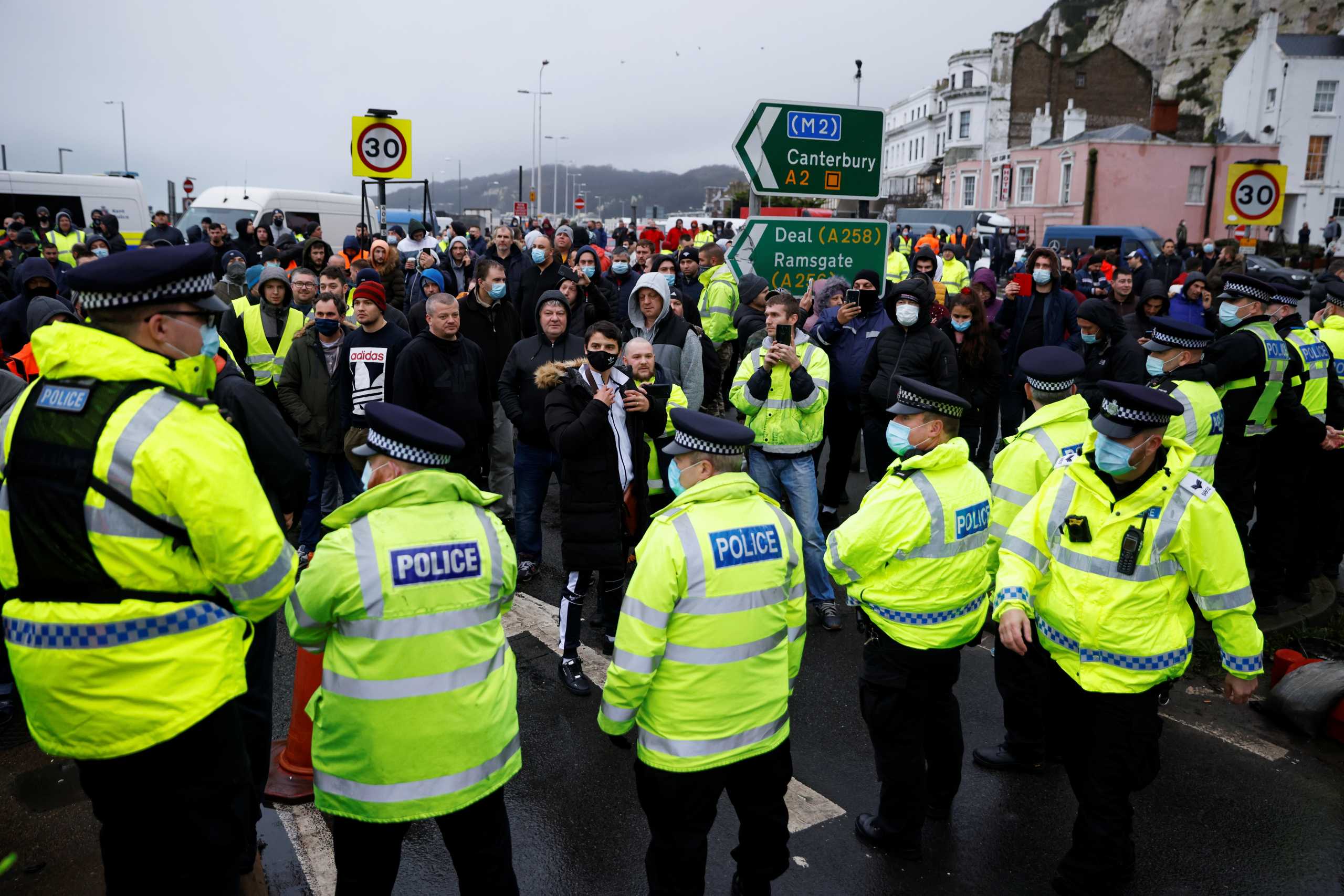 Drivers stand in front of police officers as they block the exit at the Port of Dover, as EU countries impose a travel ban from the UK following the coronavirus disease (COVID-19) outbreak, in Dover, Britain, December 23, 2020. REUTERS