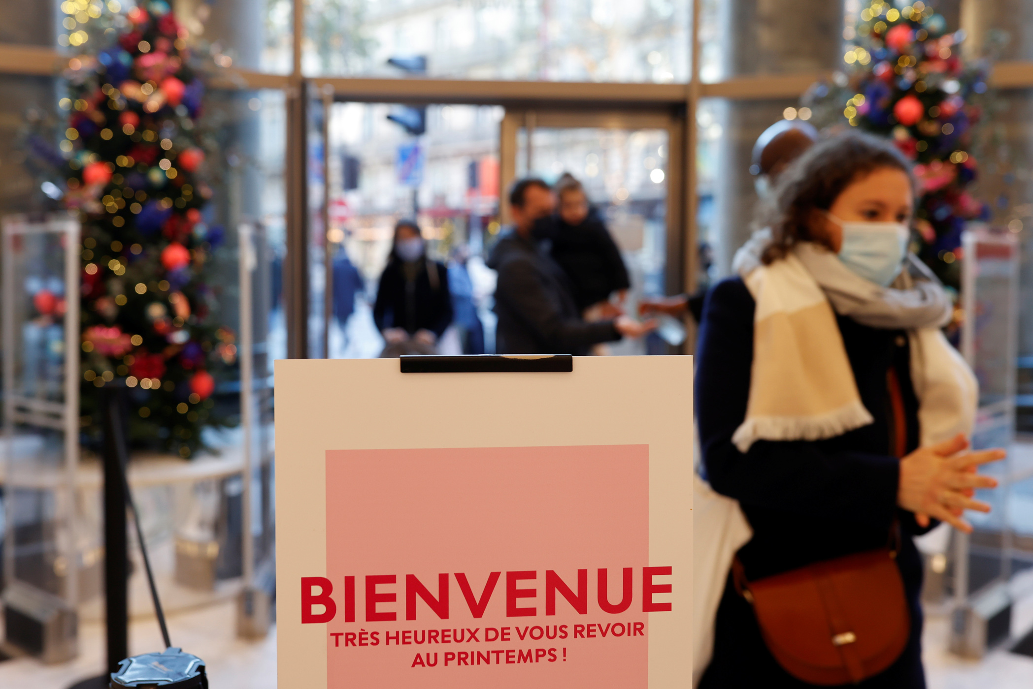 People wearing protective face masks visit the department store Le Printemps Haussmann as shops reopen doors after weeks of lockdown to combat a resurgence of the coronavirus disease (COVID-19) outbreak, in Paris, France, November 28, 2020.  REUTERS