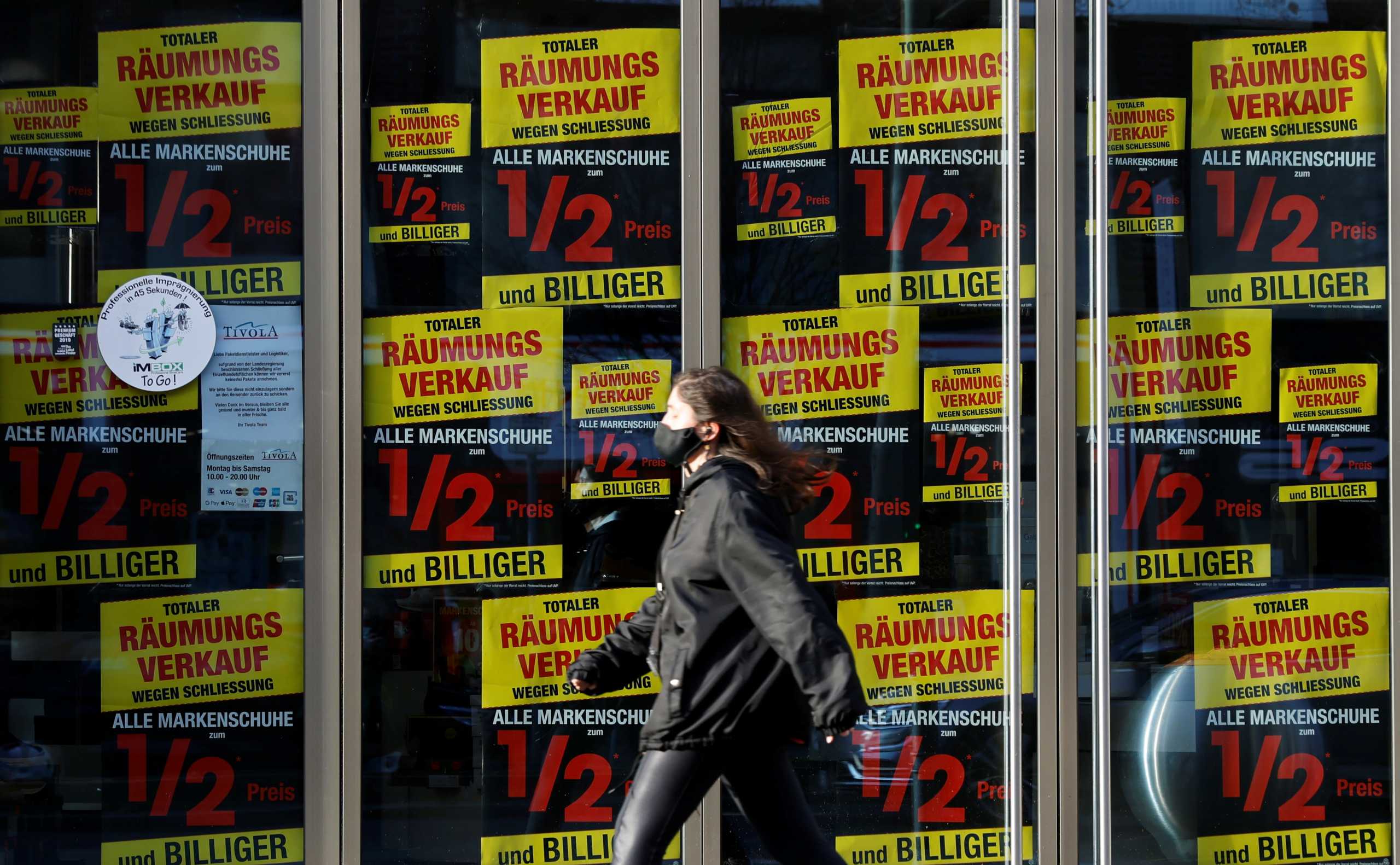 A closed shoe store is pictured  at Schloss Strasse shopping street, amid the coronavirus disease (COVID-19) pandemic during lockdown in Berlin, Germany, December 17, 2020. The words read "Total evacuation due to closure. All brand shoes half price and cheaper."   REUTERS