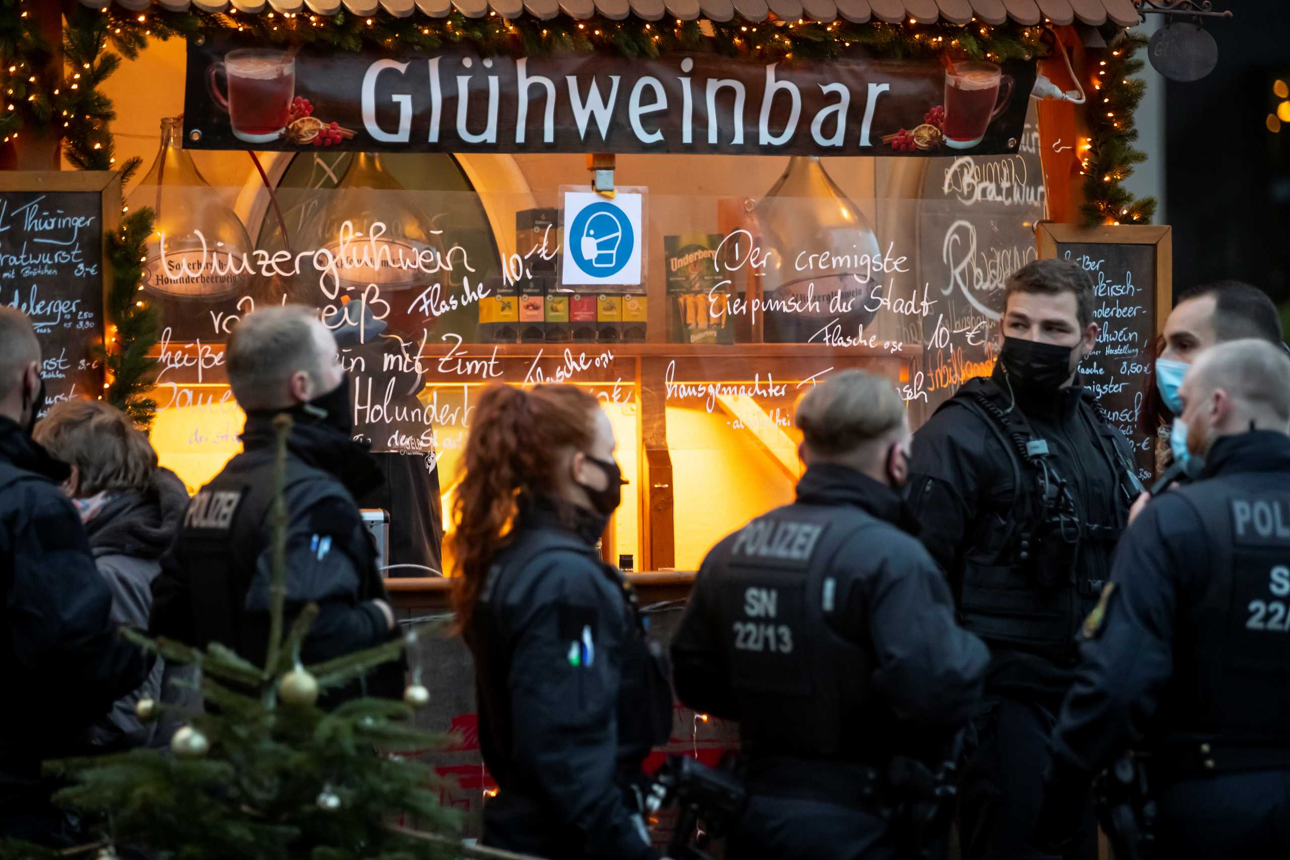 Police stay in front of a mulled wine booth during coronavirus measures (COVID-19) in Dresden, Germany, December 12, 2020. REUTERS