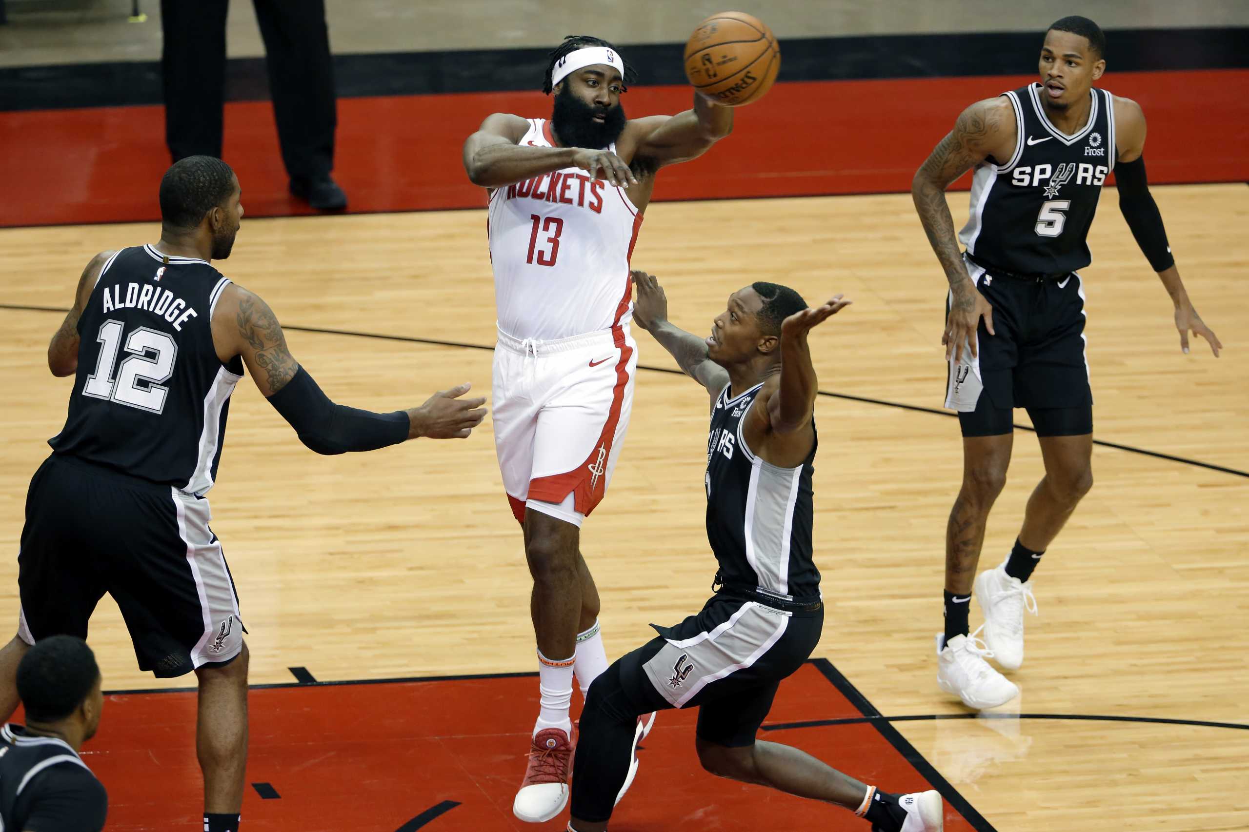 Dec 15, 2020; Houston, TX, USA; Houston Rockets guard James Harden (13) passes the ball over San Antonio Spurs forward LaMarcus Aldridge (12) and guard Lonnie Walker IV (middle right) and guard Dejounte Murray (5) during the first half. Mandatory Credit: Mike Wyke