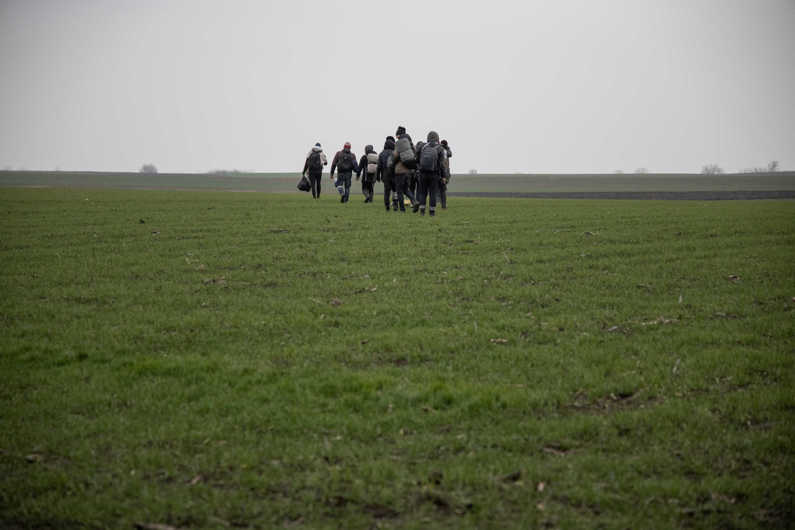 Migrants walk on a field in an attempt to cross the Serbia, Hungary and Romania border near the village of Majdan, Serbia, December 16, 2020. Hundreds of migrants from the Middle East and Africa live in abandoned houses on the outskirts of villages in northern Serbia close to Hungary and Romania borders waiting for a chance to continue their journey into Western Europe. In order to bypass a razor wire fence set up by Hungary along the Serbian border during the 2015 migrant crisis, most follow an alternative route via Romania. Picture taken December 16, 2020. REUTERS