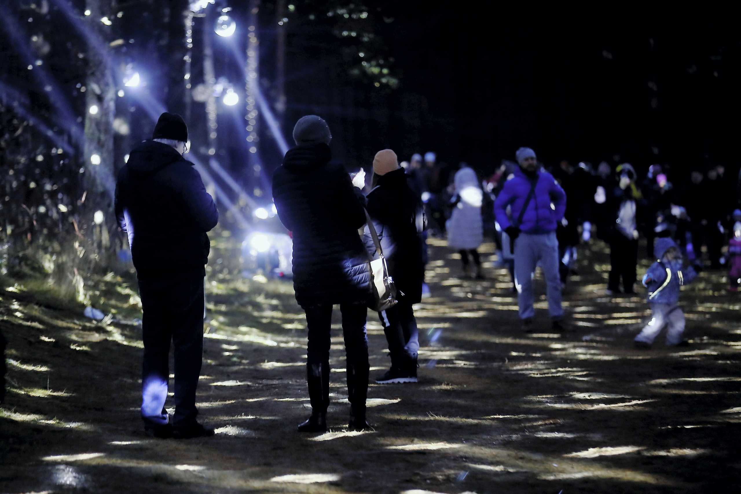 People walk in the illuminated city forest in Riga, Latvia December 20, 2020. REUTERS