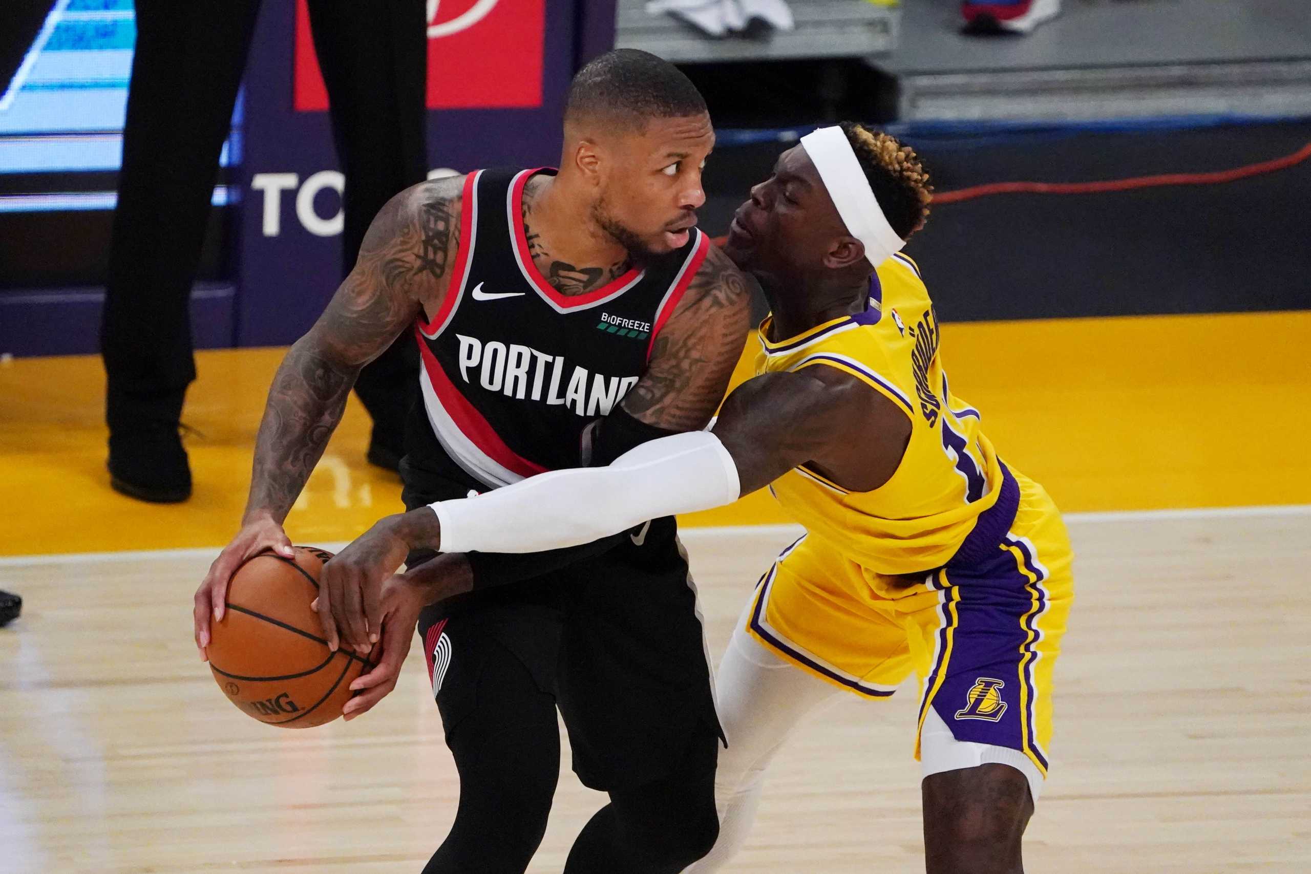Dec 28, 2020; Los Angeles, California, USA; Portland Trail Blazers guard Damian Lillard (0) is defended by Los Angeles Lakers guard Dennis Schroder (17) in the fourth quarter at Staples Center. The Trail Blazers defeated the Lakers 115-107. Mandatory Credit: Kirby Lee-USA TODAY Sports