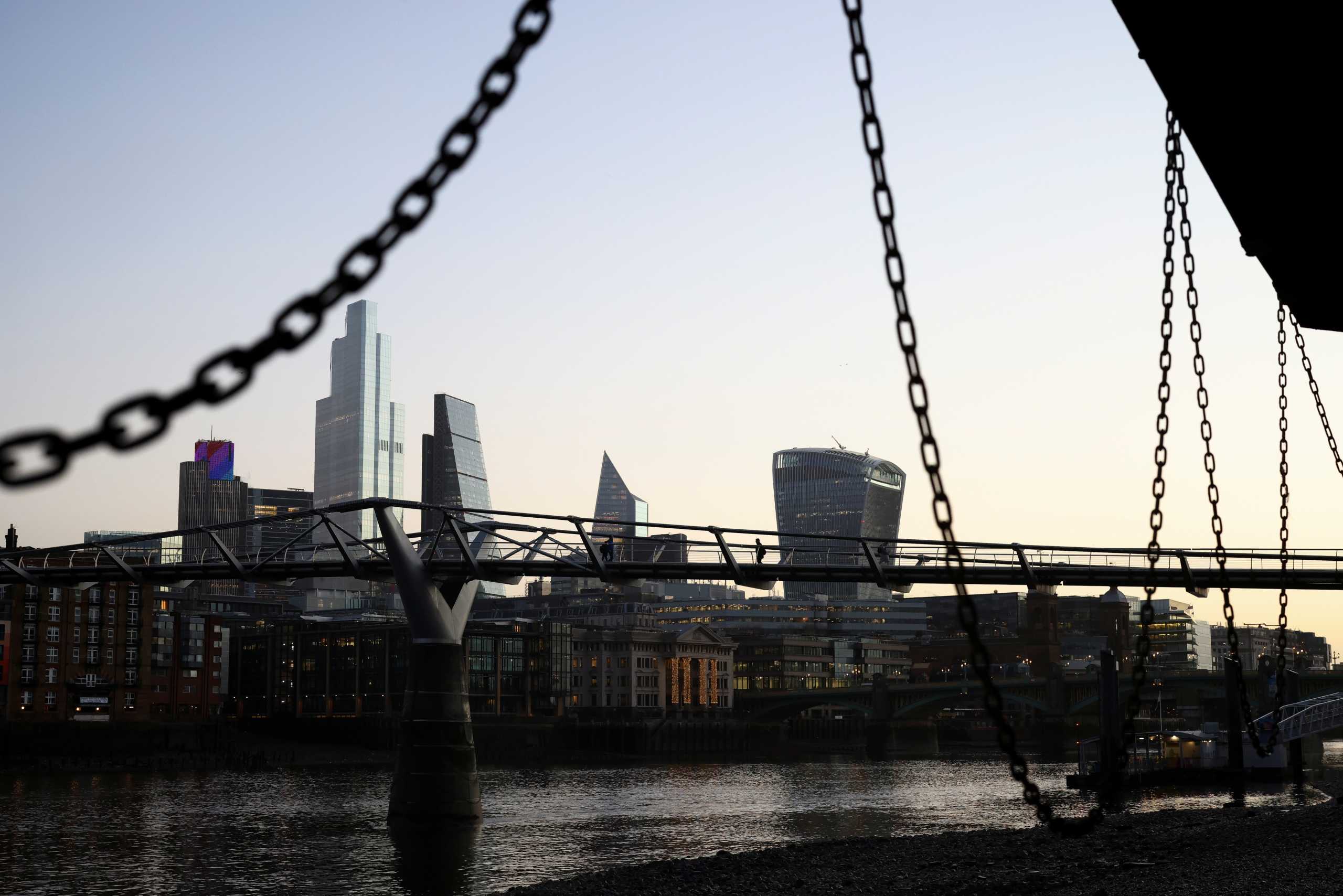The financial district can be seen as people walk across Millennium Bridge, amid the coronavirus disease (COVID-19) outbreak, in London, Britain, December 14, 2020. REUTERS
