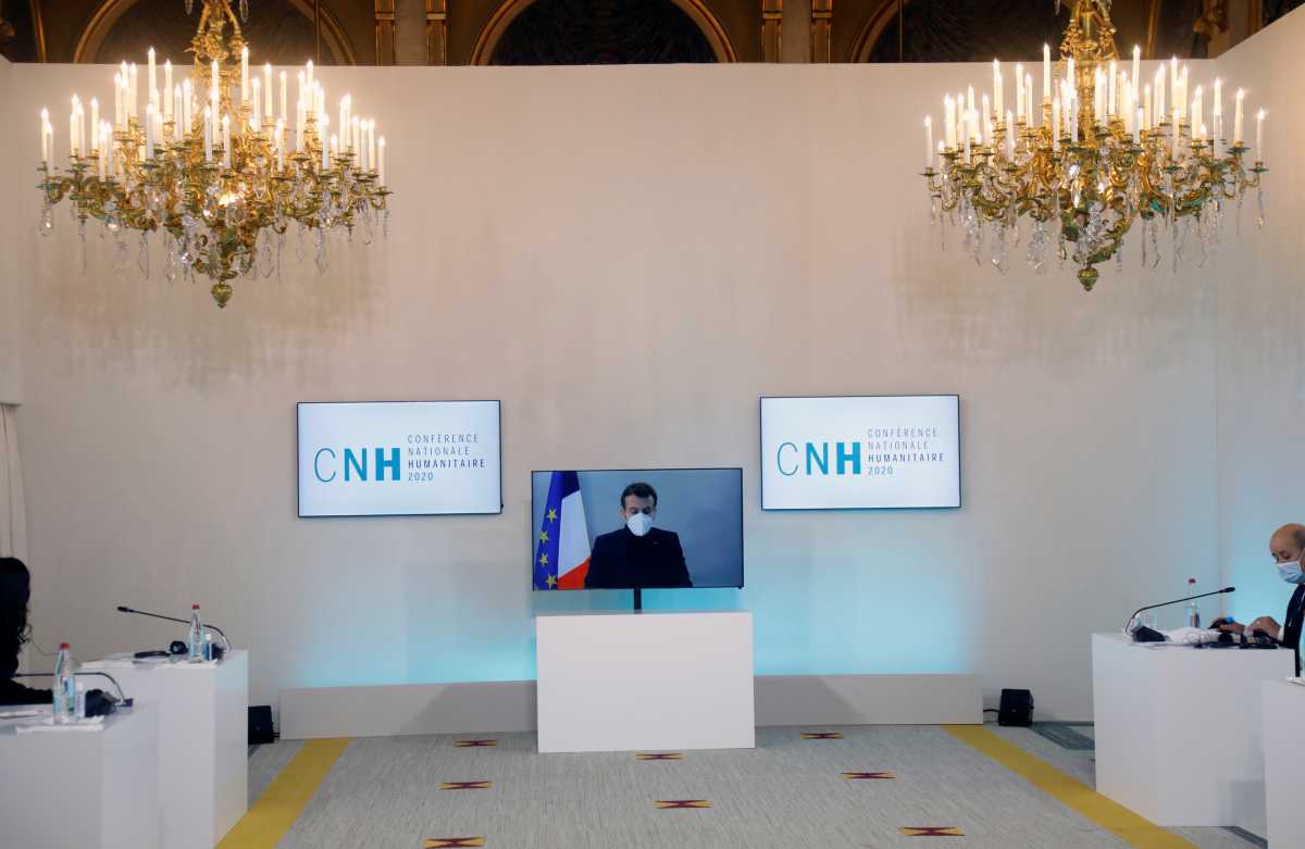 French President Emmanuel Macron, tested positive for the coronavirus disease (COVID-19), is seen on a screen as he attends by video conference a round table for the National Humanitarian Conference (NHC) at the Foreign Affairs Ministry in Paris, France, December 17, 2020. REUTERS