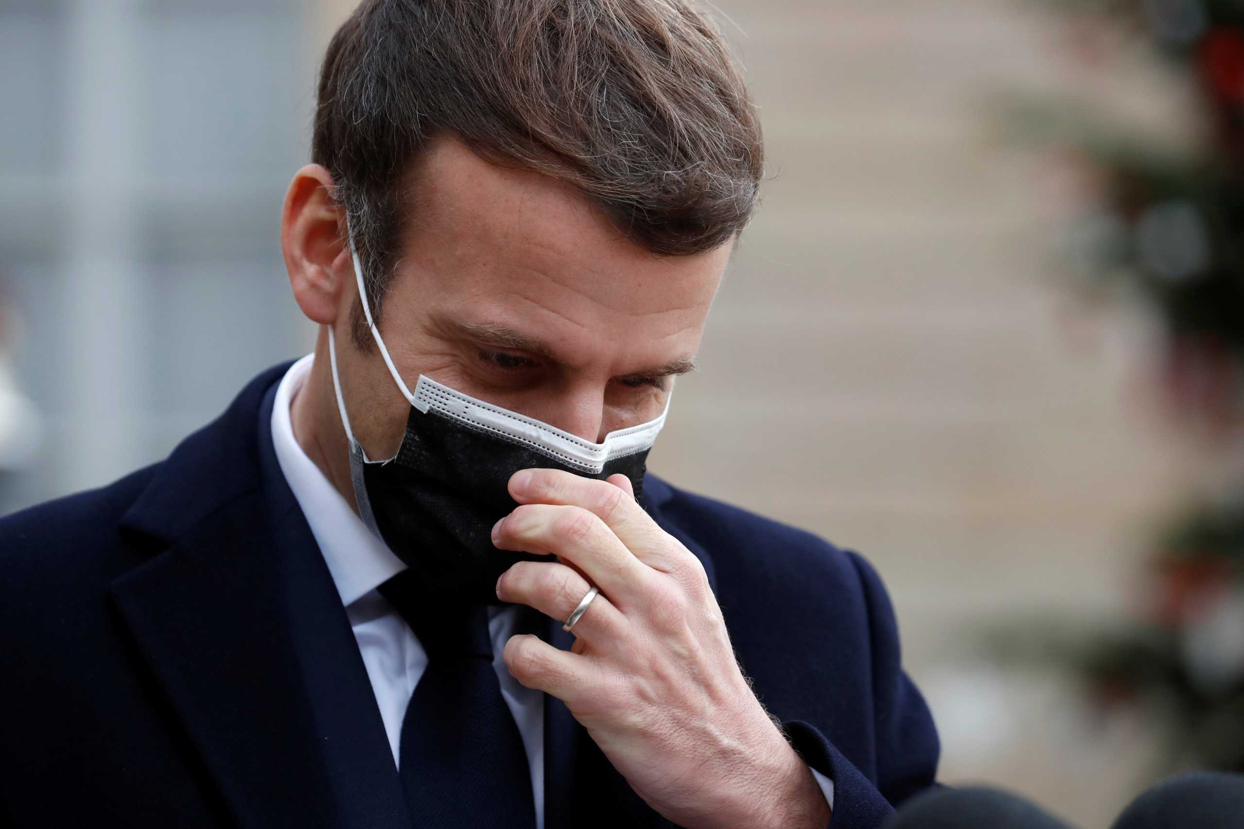 French President Emmanuel Macron, wearing a protective face mask, adjusts his protective face mask as he talks to the media with Portugal's Prime Minister Antonio Costa (not seen) before a meeting at the Elysee Palace in Paris, France, December 16, 2020. Picture taken December 16, 2020. REUTERS