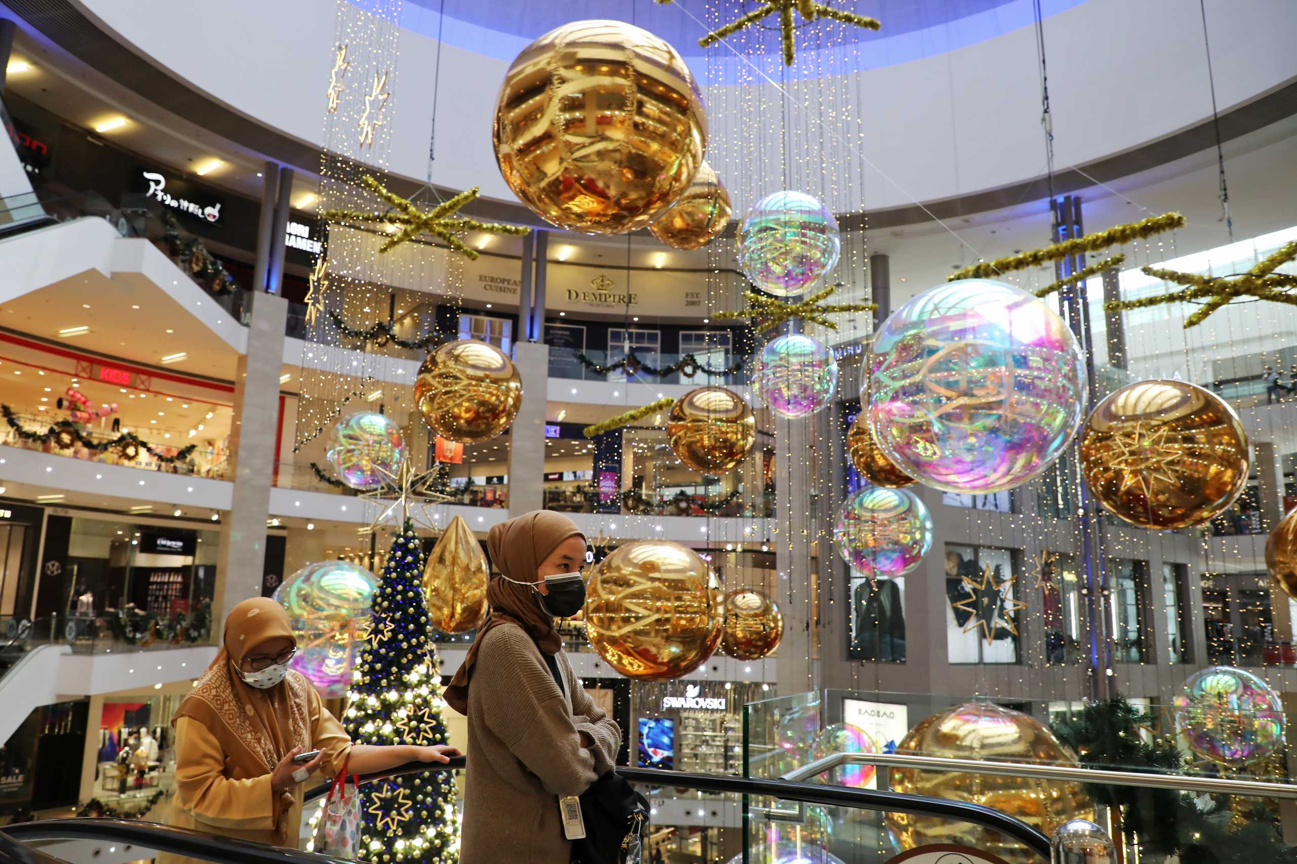 Shoppers wearing protective masks walk past Christmas decorations inside a mall amid the coronavirus disease (COVID-19) outbreak in Kuala Lumpur, Malaysia December 9, 2020. REUTERS