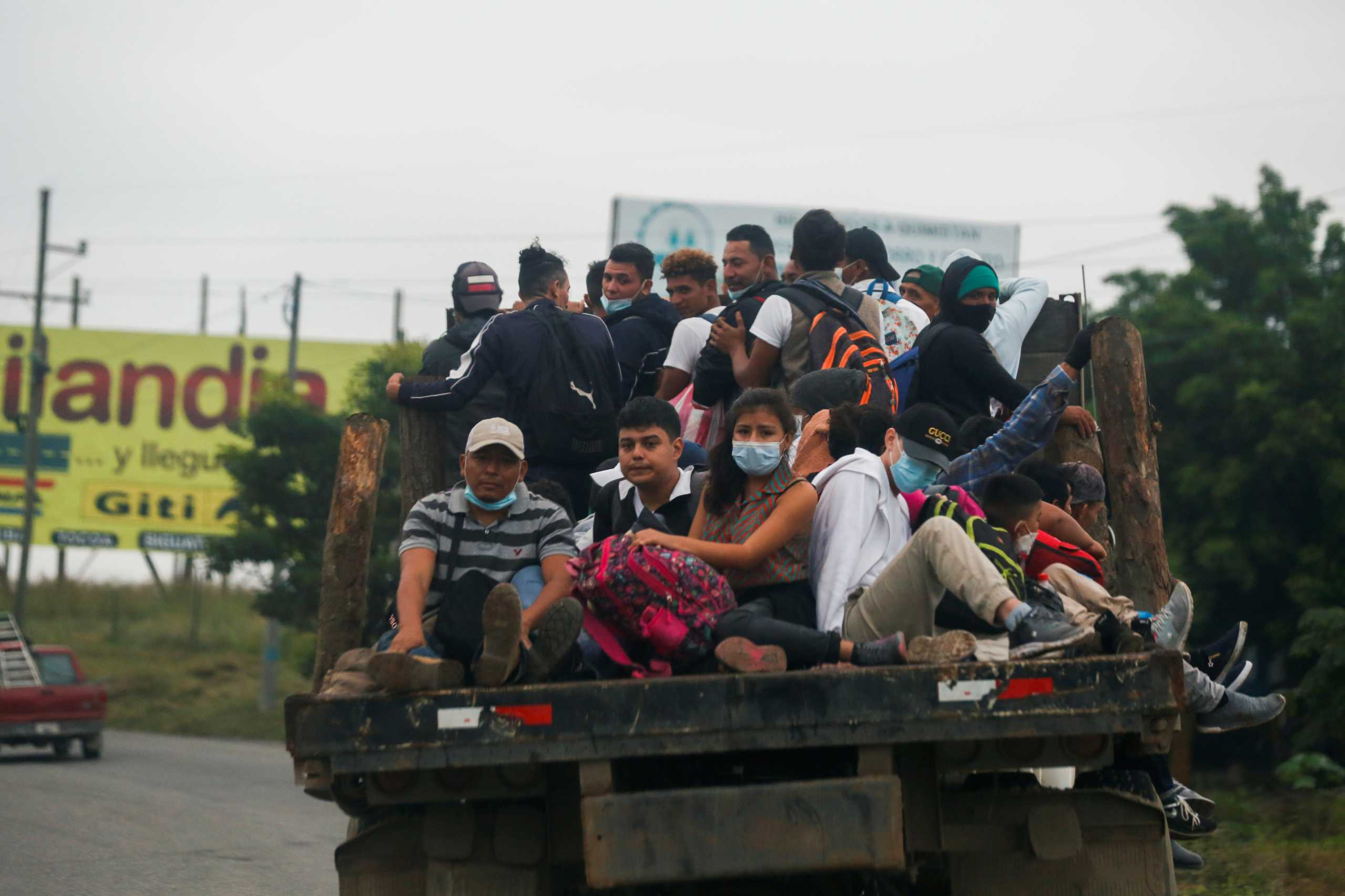 Hondurans ride in the back of a truck as they take part in a new caravan of migrants, set to head to the United States, in Copan, Honduras December 10, 2020. REUTERS