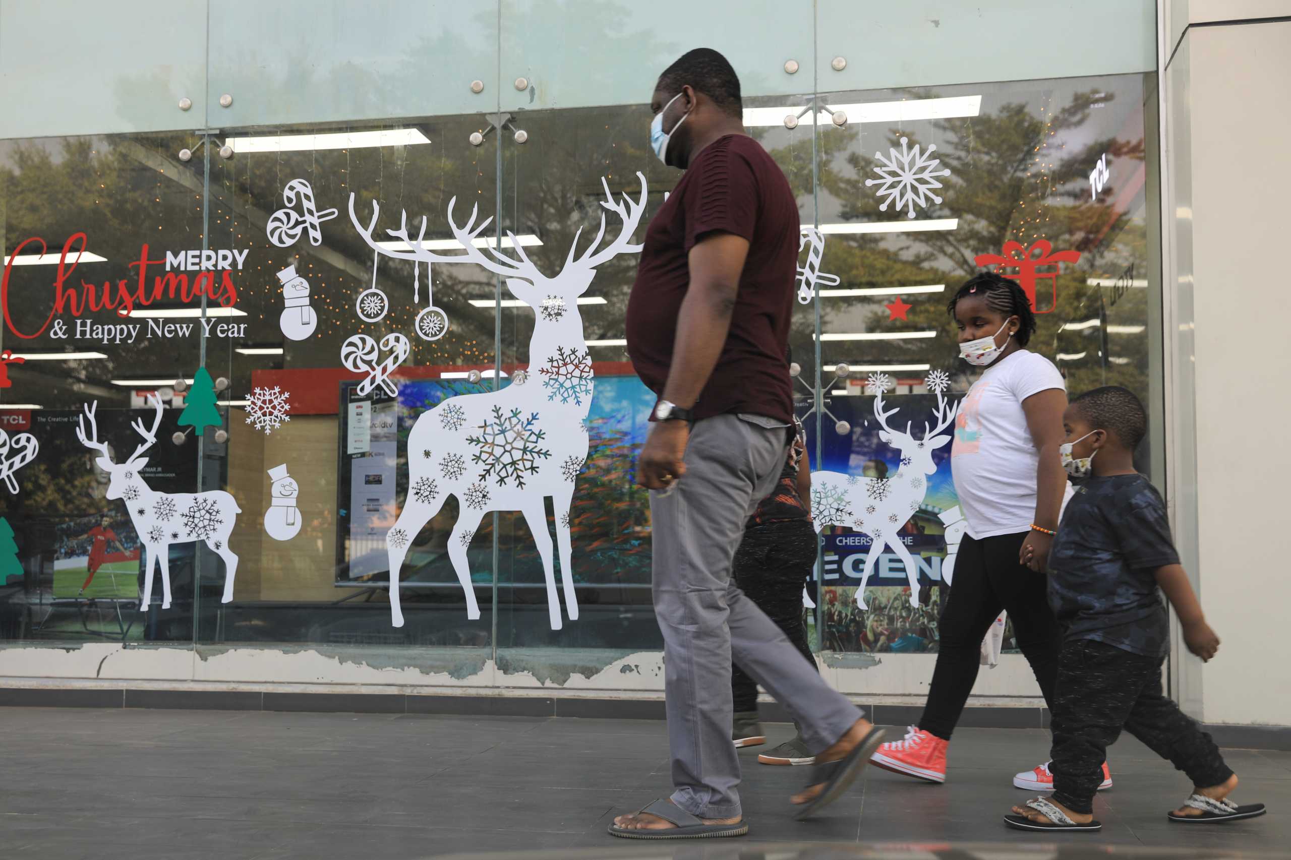A family walk past Christmas decorations at Cherries Hypermarket on the eve of Christmas during the coronavirus disease (COVID-19) outbreak in Abuja, Nigeria December 24, 2020. REUTERS