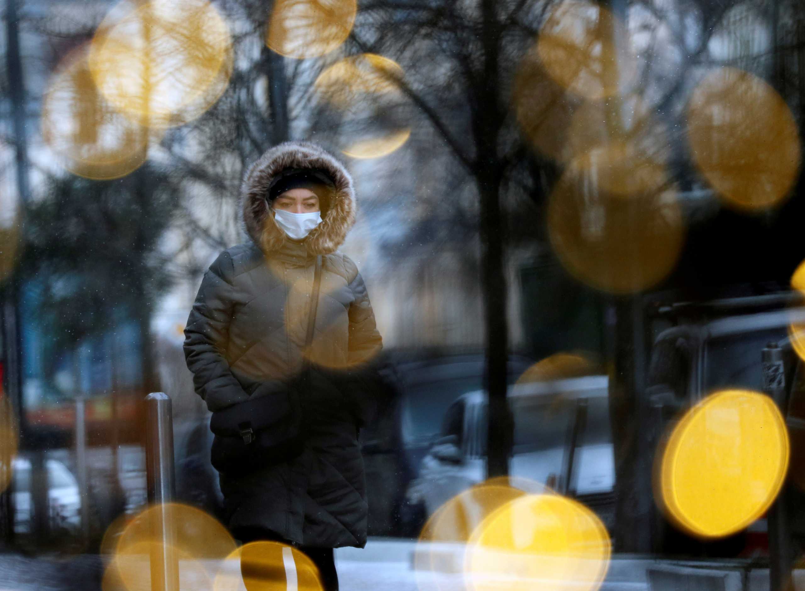 A woman wearing a protective face mask walks past Christmas illumination, amid the outbreak of the coronavirus disease (COVID-19), in Kyiv, Ukraine December 8, 2020.  REUTERS