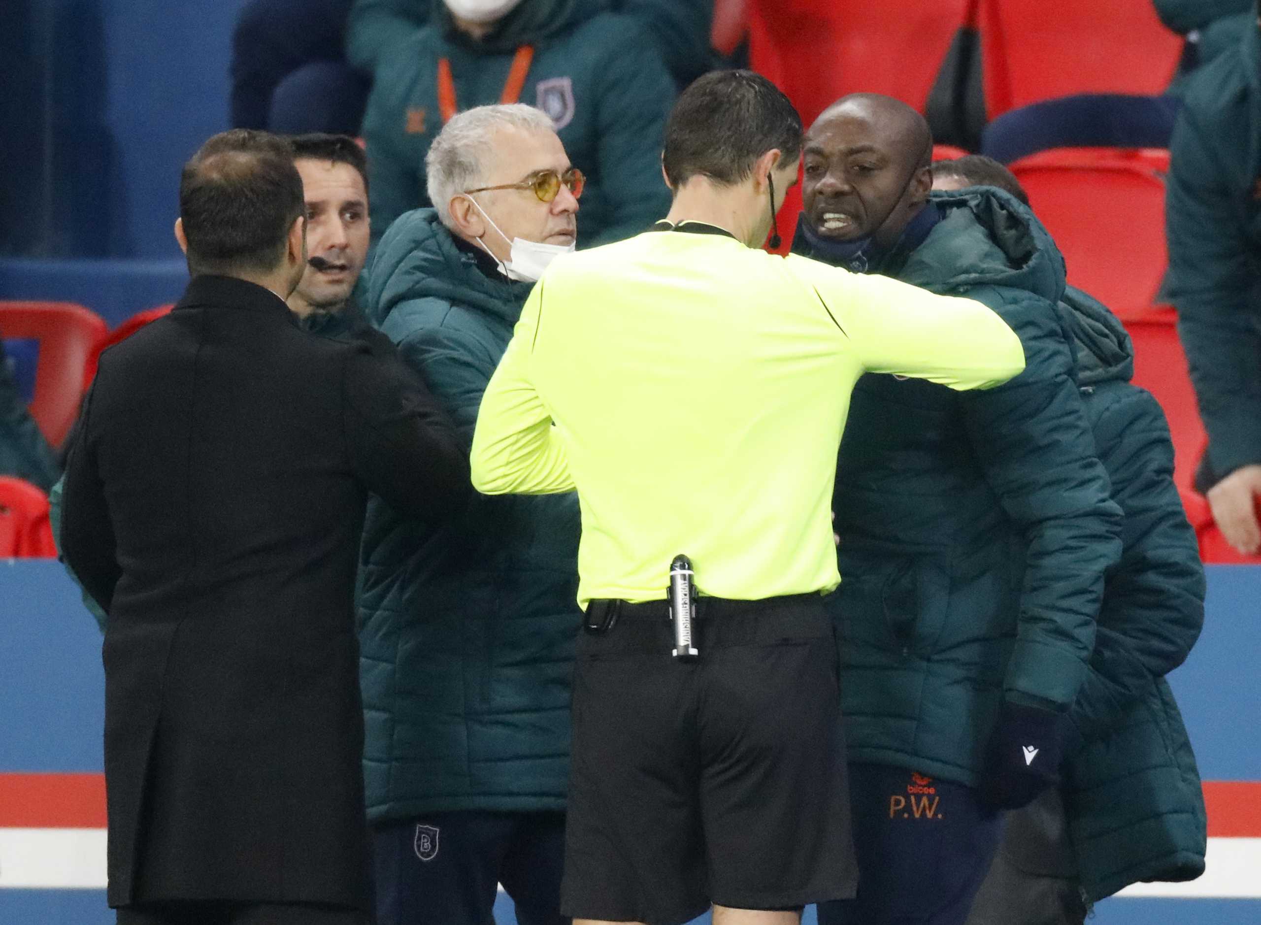 Soccer Football - Champions League - Group H - Paris St Germain v Istanbul Basaksehir F.K. - Parc des Princes, Paris, France - December 8, 2020 Referee Ovidiu Hategan with Istanbul Basaksehir coaching staff as the match is interrupted REUTERS