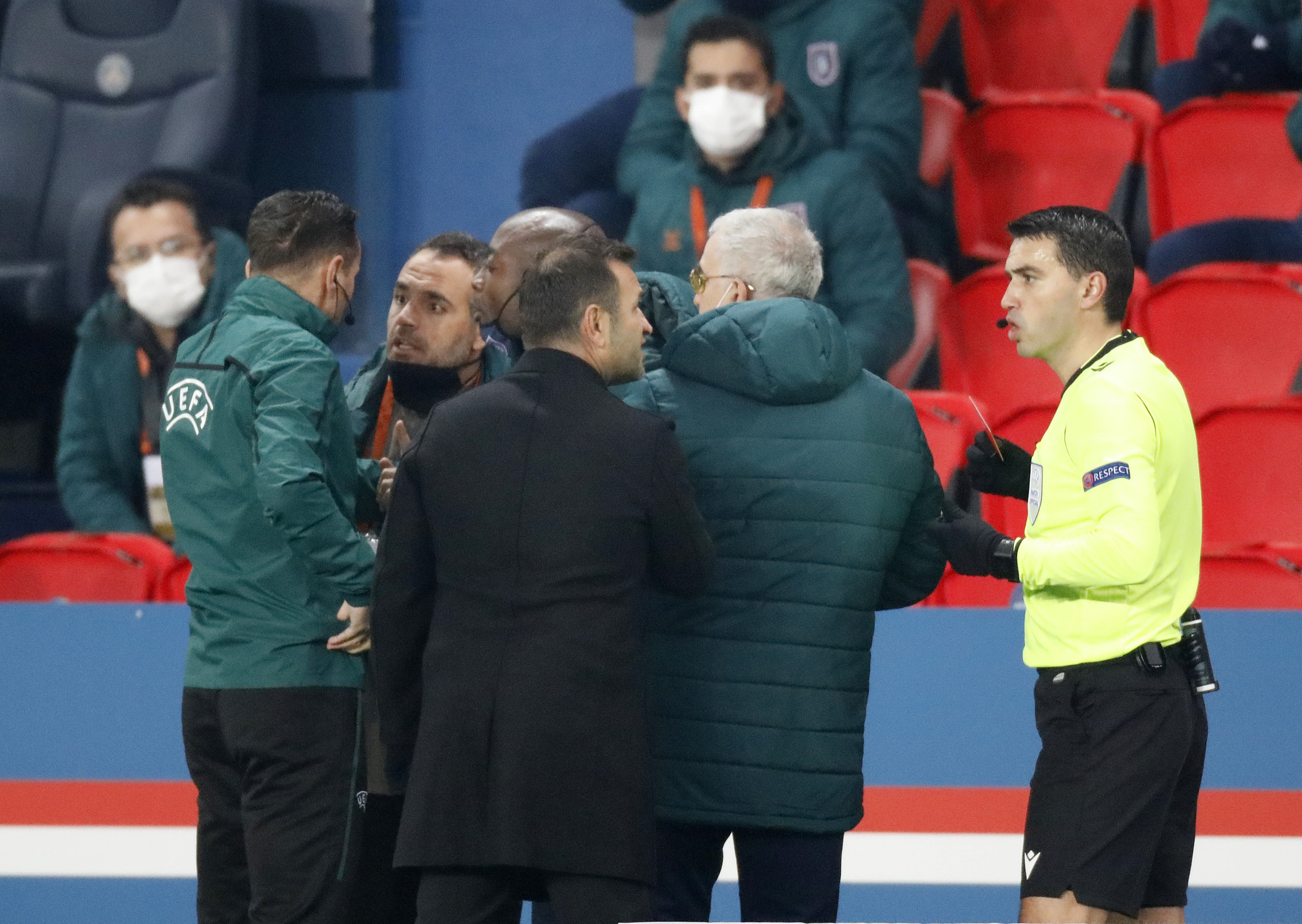 Soccer Football - Champions League - Group H - Paris St Germain v Istanbul Basaksehir F.K. - Parc des Princes, Paris, France - December 8, 2020 Fourth official Sebastian Coltescu with Istanbul Basaksehir assistant coach Pierre Webo and referee Ovidiu Hategan with Istanbul Basaksehir coach Okan Buruk as the match is interrupted REUTERS