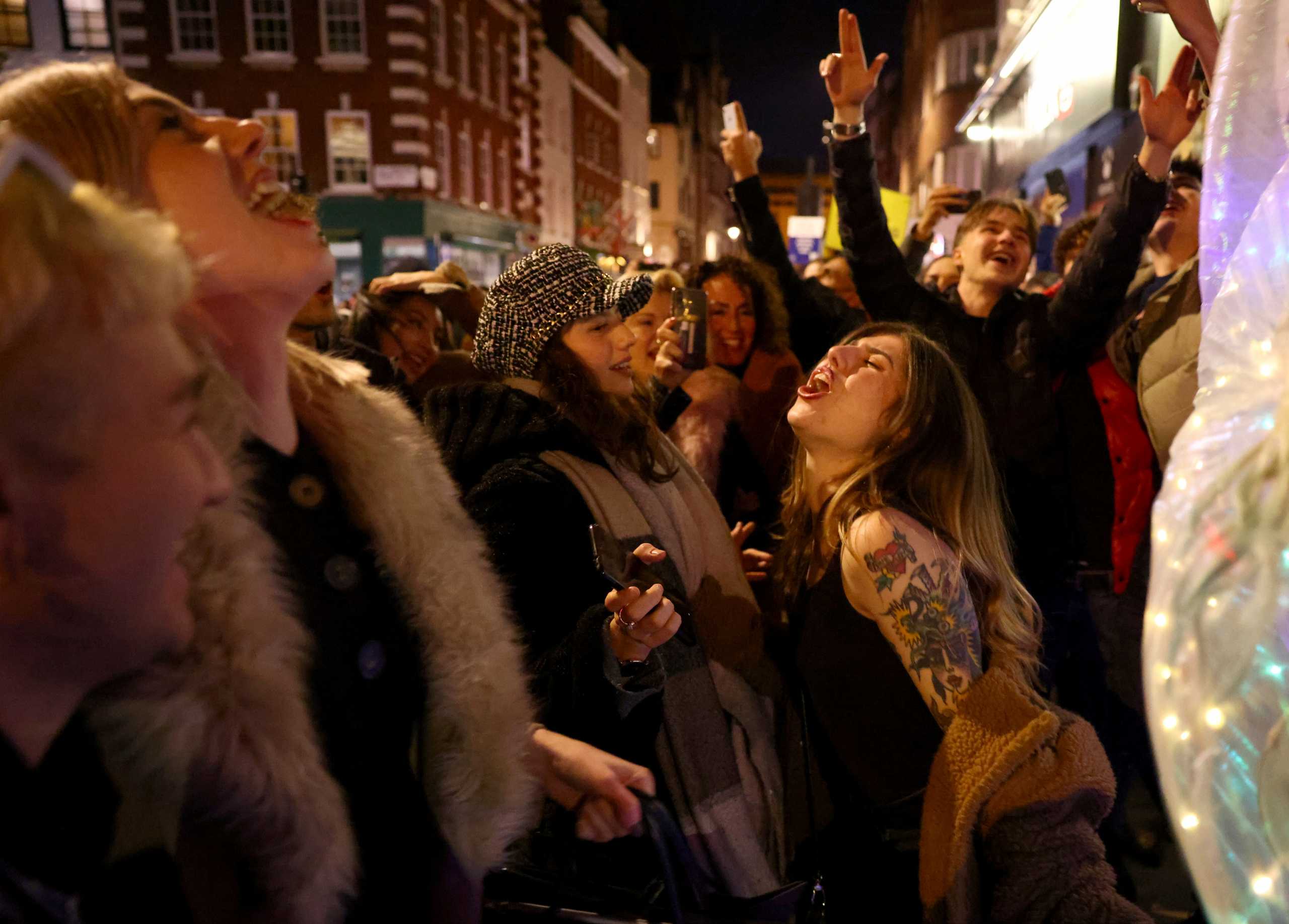 People party on a street as pubs shut for the night due to tier 3 restrictions in Soho, as the spread of the coronavirus disease (COVID-19) continues in London, Britain, December 15, 2020.  REUTERS