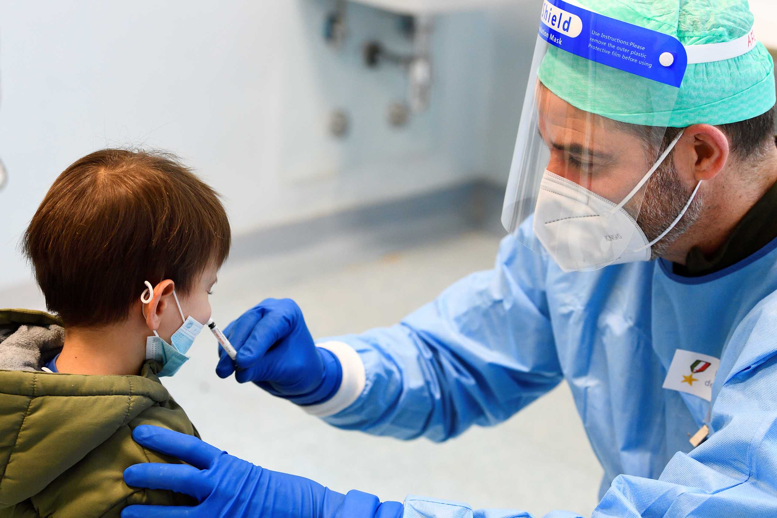 A military doctor administers a flu vaccine to a child in a military hospital after health authorities advised people to take a flu vaccine to avoid confusion with the coronavirus disease (COVID-19) symptoms, in Milan, Italy, November 20, 2020. REUTERS