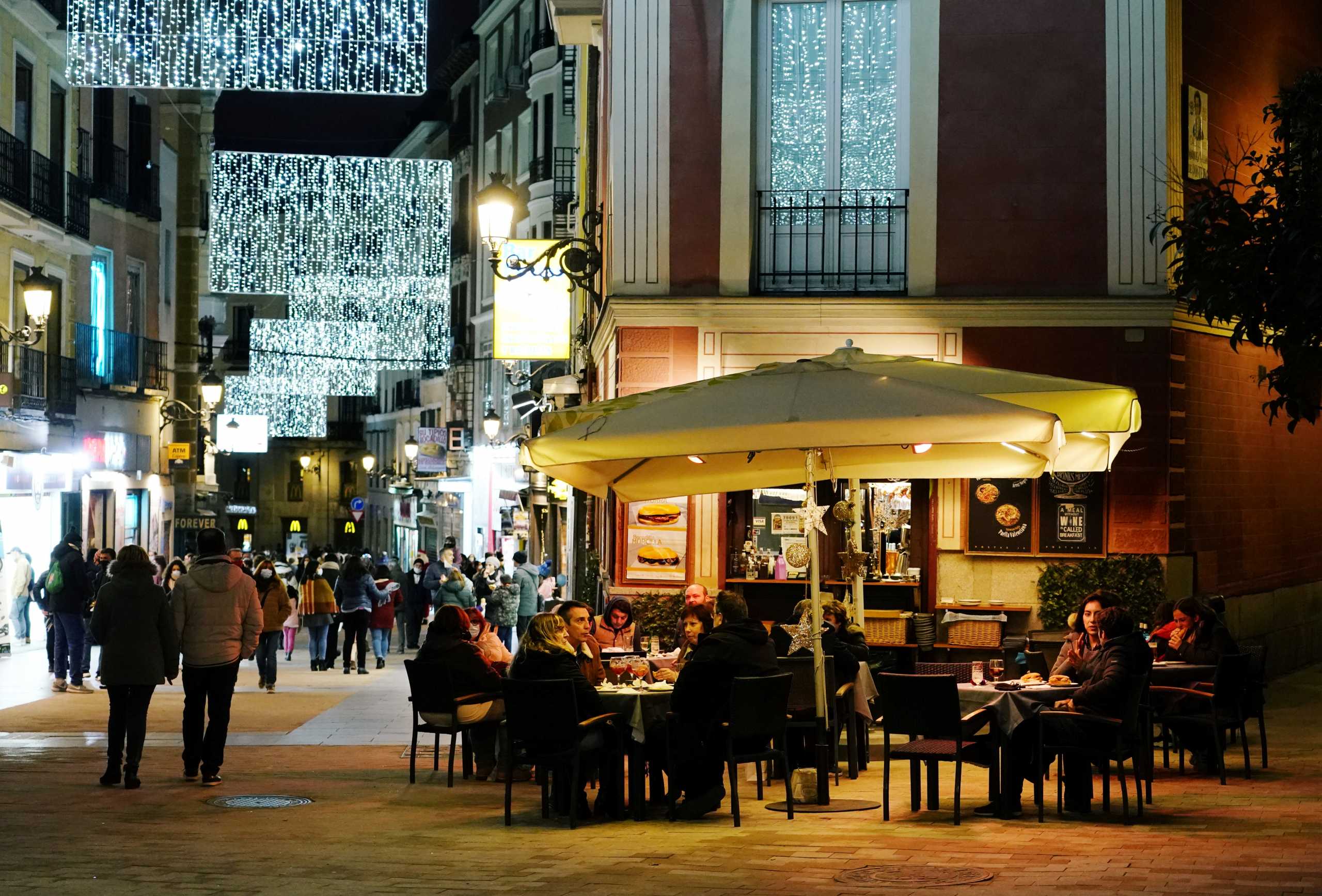 People sit on a terrace amid the coronavirus disease (COVID-19) pandemic in Madrid, Spain December 15, 2020. Picture taken December 15, 2020. REUTERS