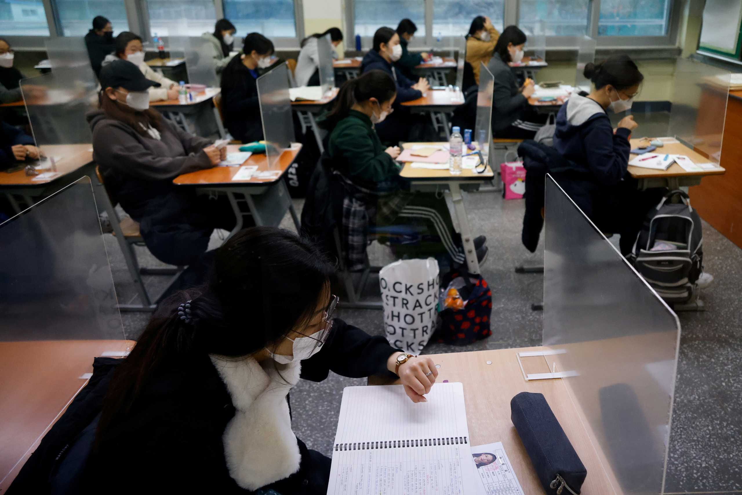 A student checks the time as the others wait for the start of the annual college entrance examinations amid the coronavirus disease (COVID-19) pandemic at an exam hall in Seoul, South Korea, December 3, 2020.   REUTERS