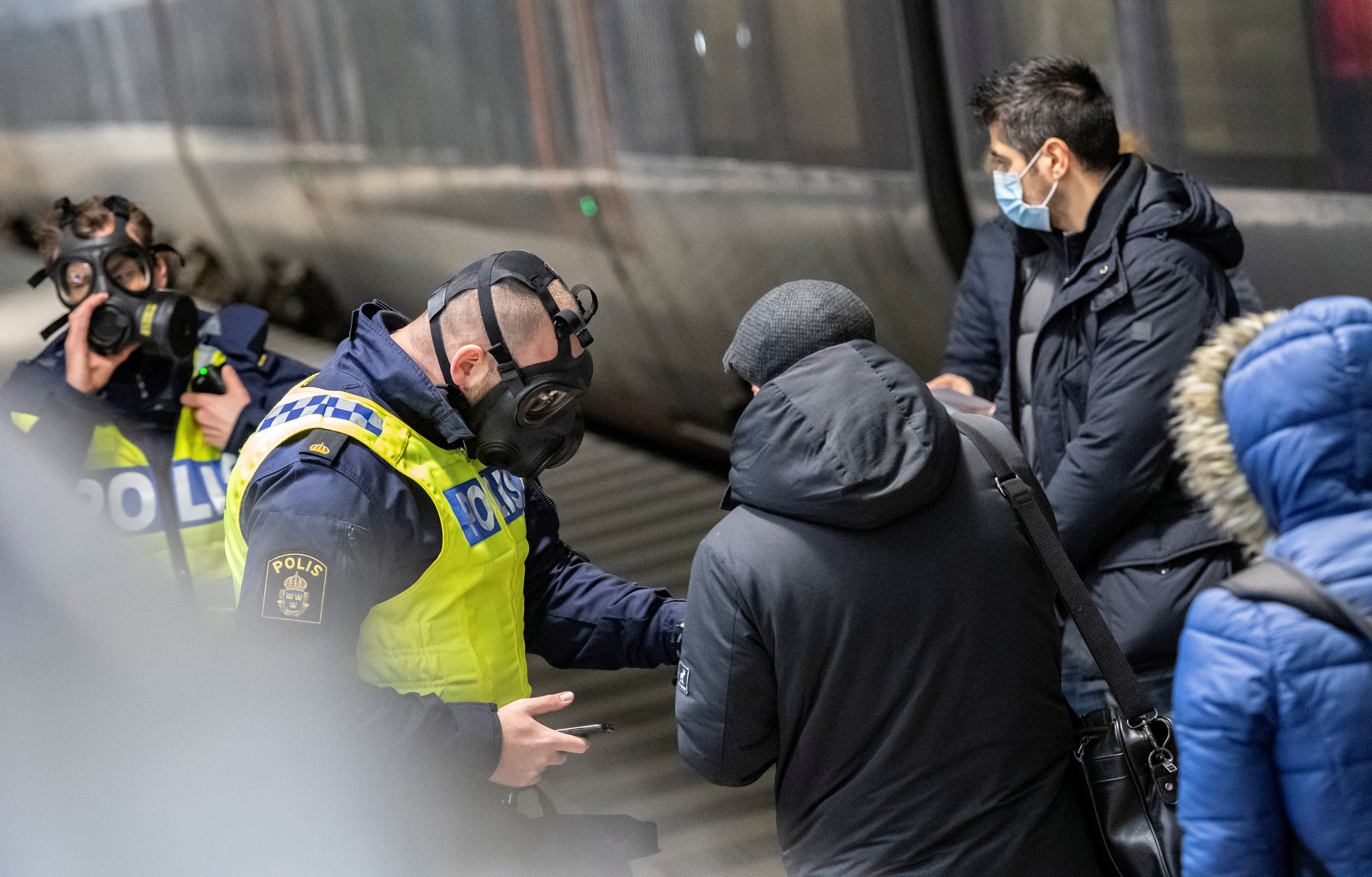 Travellers from Denmark are met by Swedish police in protective masks at the border control point at Hyllie station, as the Swedish government shut the border after a mutated strain of the coronavirus was discovered in Denmark, in Malmo, Sweden December 22, 2020. TT News Agency