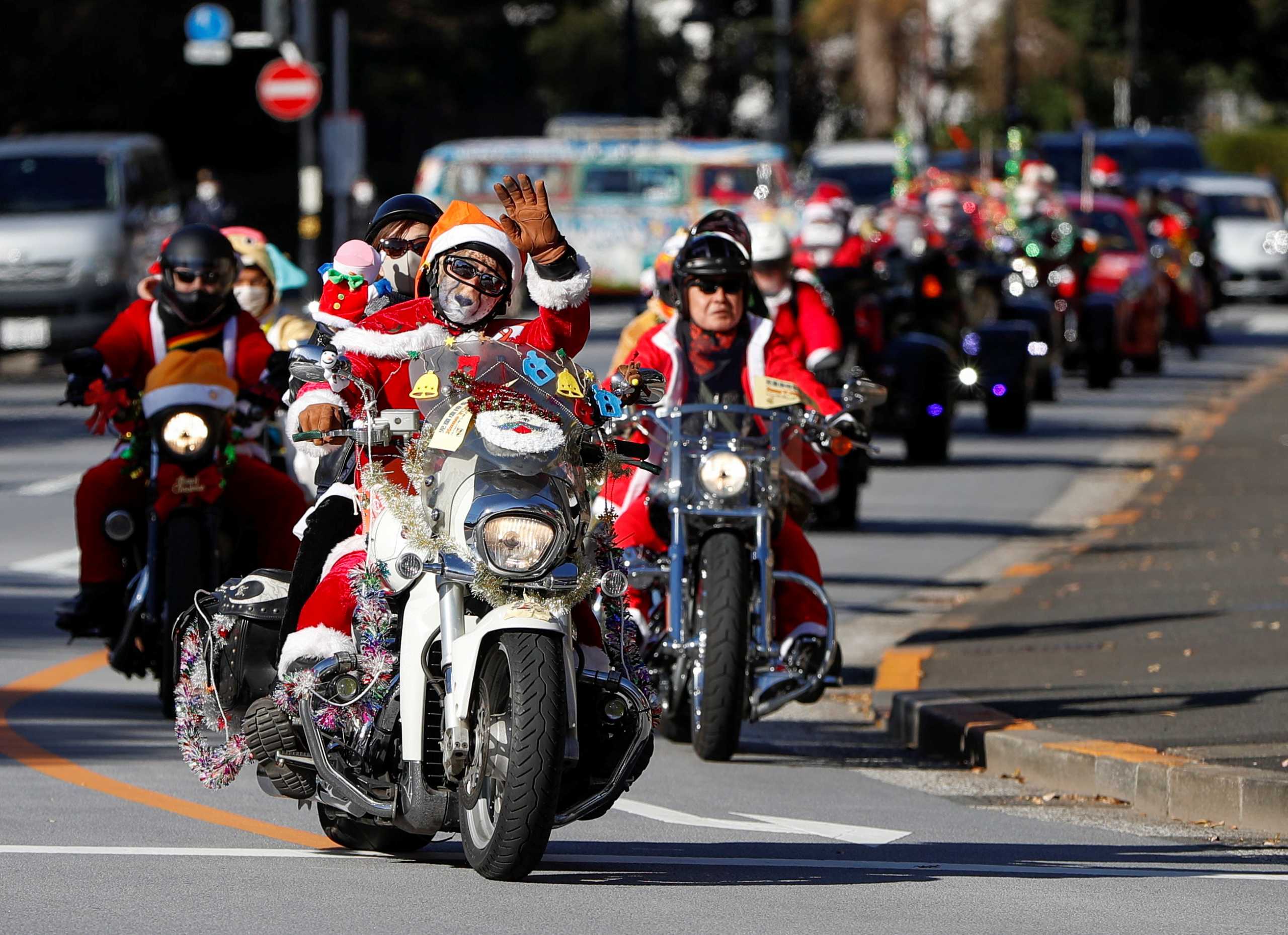 People dressed in Santa Claus costumes ride their motorbikes during Xmas Toy Run parade to rev up the holiday spirit and rally against child abuse, organised by Harley Santa Club, amid the coronavirus disease (COVID-19) outbreak, in Tokyo, Japan December 20, 2020.  REUTERS