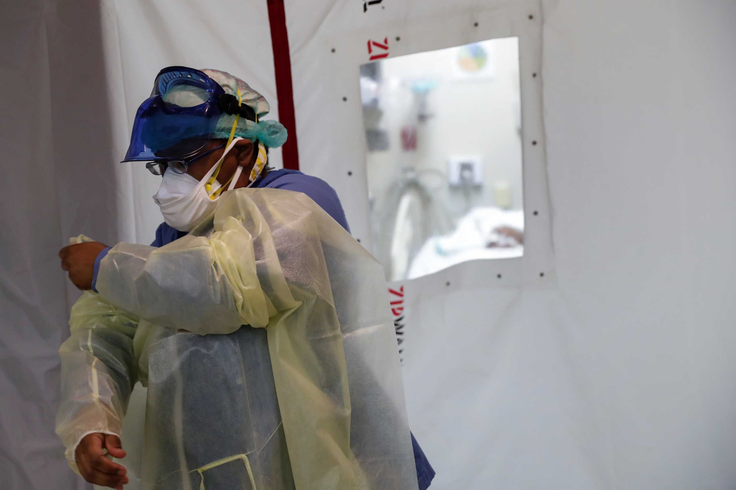 Registered nurse Tamara Jones dresses in Personal Protective Equipment (PPE), as the global outbreak of the coronavirus disease (COVID-19) continues, outside an isolation room in the intensive care unit at Roseland Community Hospital on the South Side of Chicago, Illinois, U.S., December 8, 2020. REUTERS