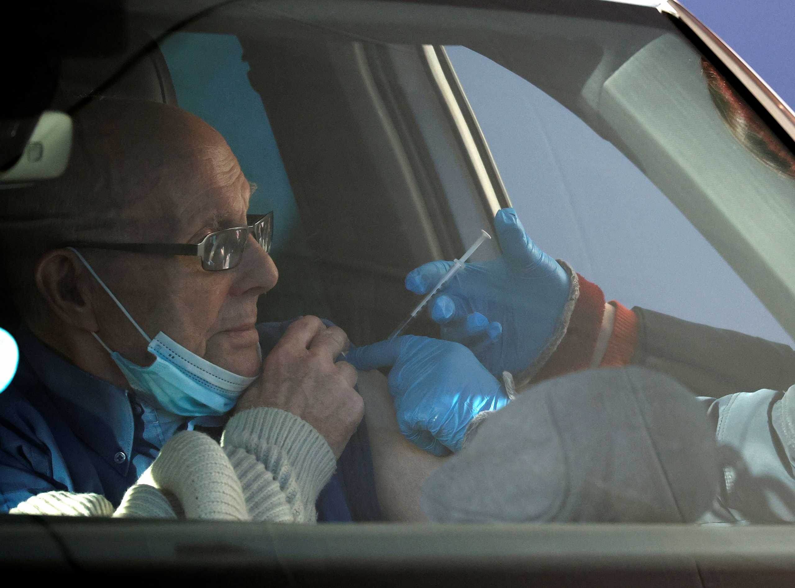 A man receives the Pfizer-BioNTech COVID-19 vaccine at a drive through vaccination centre amid the outbreak of the coronavirus disease (COVID-19) in Hyde, Britain, December 17, 2020. REUTERS