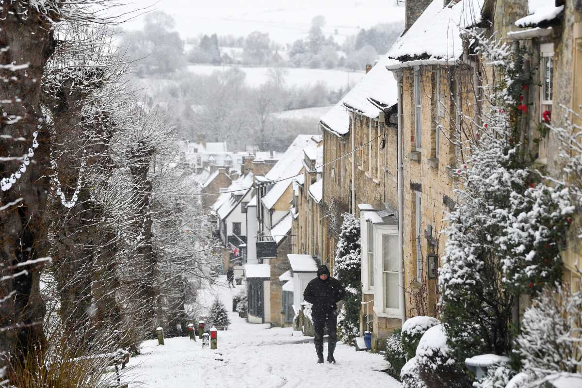 A man walks through snow in Burford, Britain December 28, 2020. REUTERS