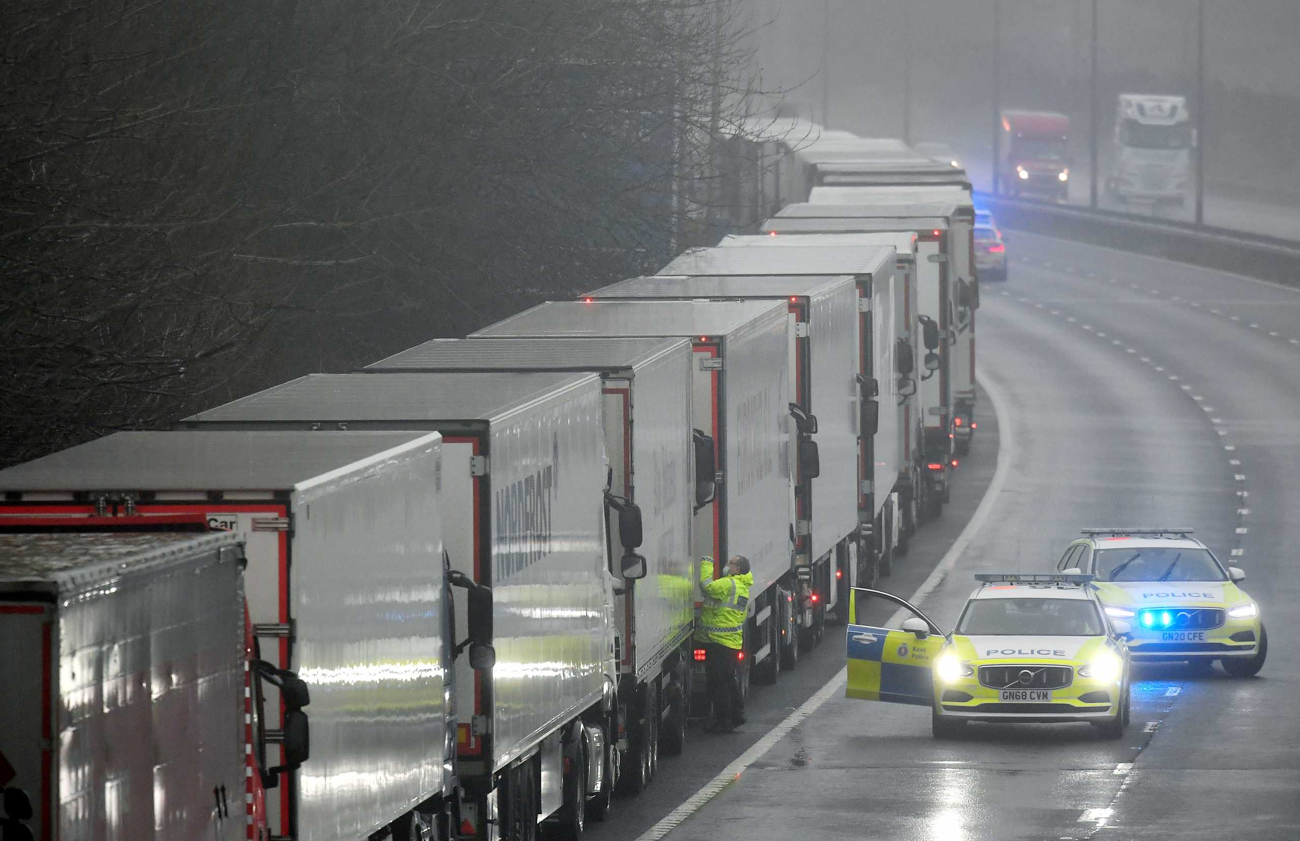 FILE PHOTO: Police officers speak to a driver in one of lorries parked on the M20 motorway towards Eurotunnel and the Port of Dover, as EU countries impose a travel ban from the UK following the coronavirus disease (COVID-19) outbreak, in Folkestone, Britain, December 21, 2020. REUTERS
