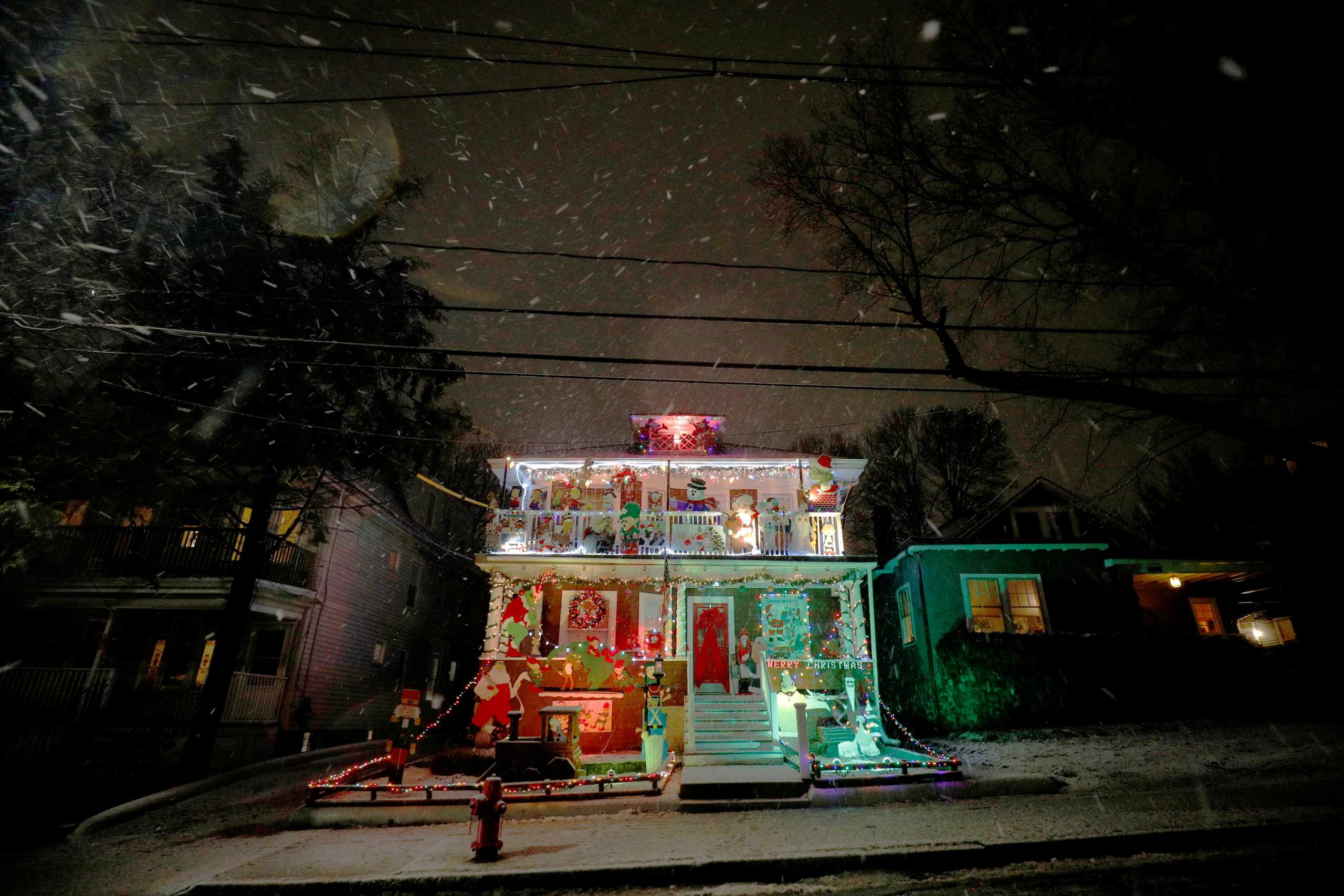 Snow falls around a house decorated for the Christmas holiday in Somerville, Massachusetts, U.S., December 5, 2020.   REUTERS