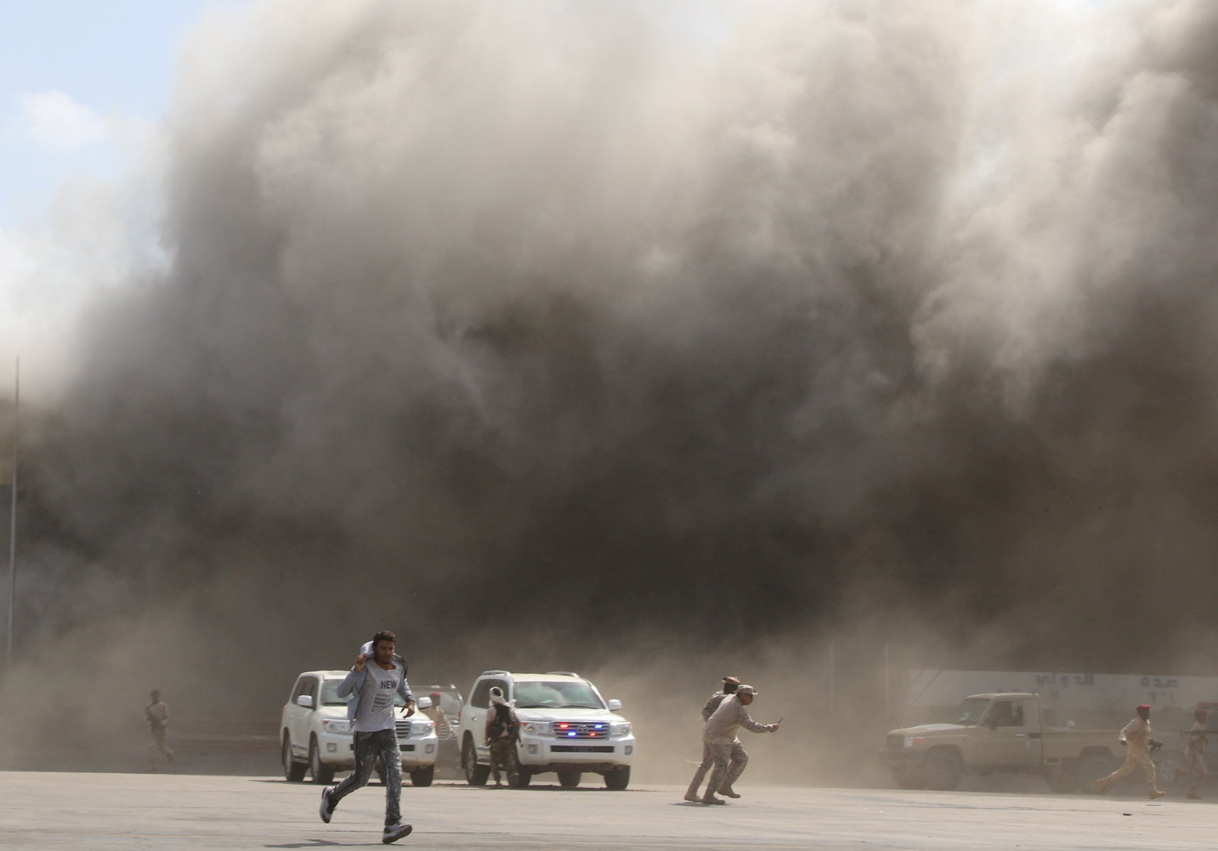 People react as dust rises after explosions hit Aden airport, upon the arrival of the newly-formed Yemeni government in Aden, Yemen December 30, 2020. REUTERS