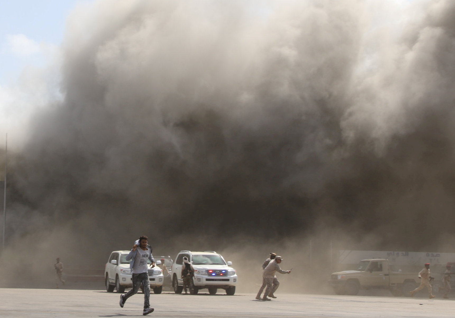 People react as dust rises after explosions hit Aden airport, upon the arrival of the newly-formed Yemeni government in Aden, Yemen December 30, 2020. REUTERS