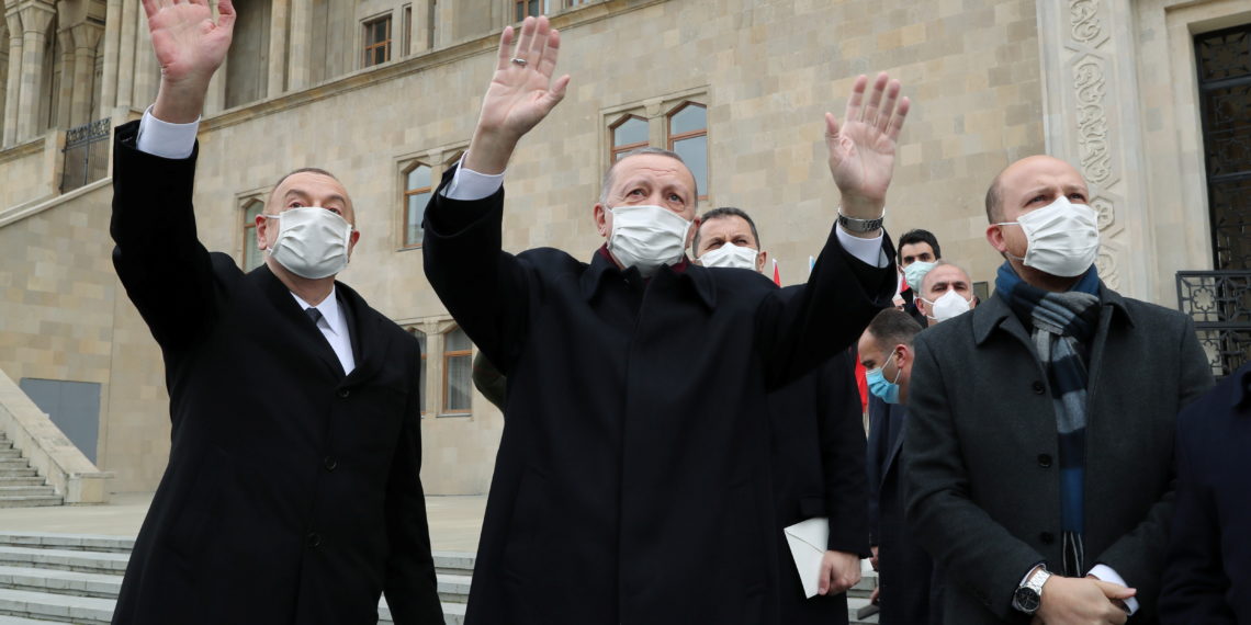 Presidents Tayyip Erdogan of Turkey and Ilham Aliyev of Azerbaijan greet people during a military parade to mark the victory on Nagorno-Karabakh conflict, in Baku, Azerbaijan December 10, 2020. Murat Cetinmuhurdar
